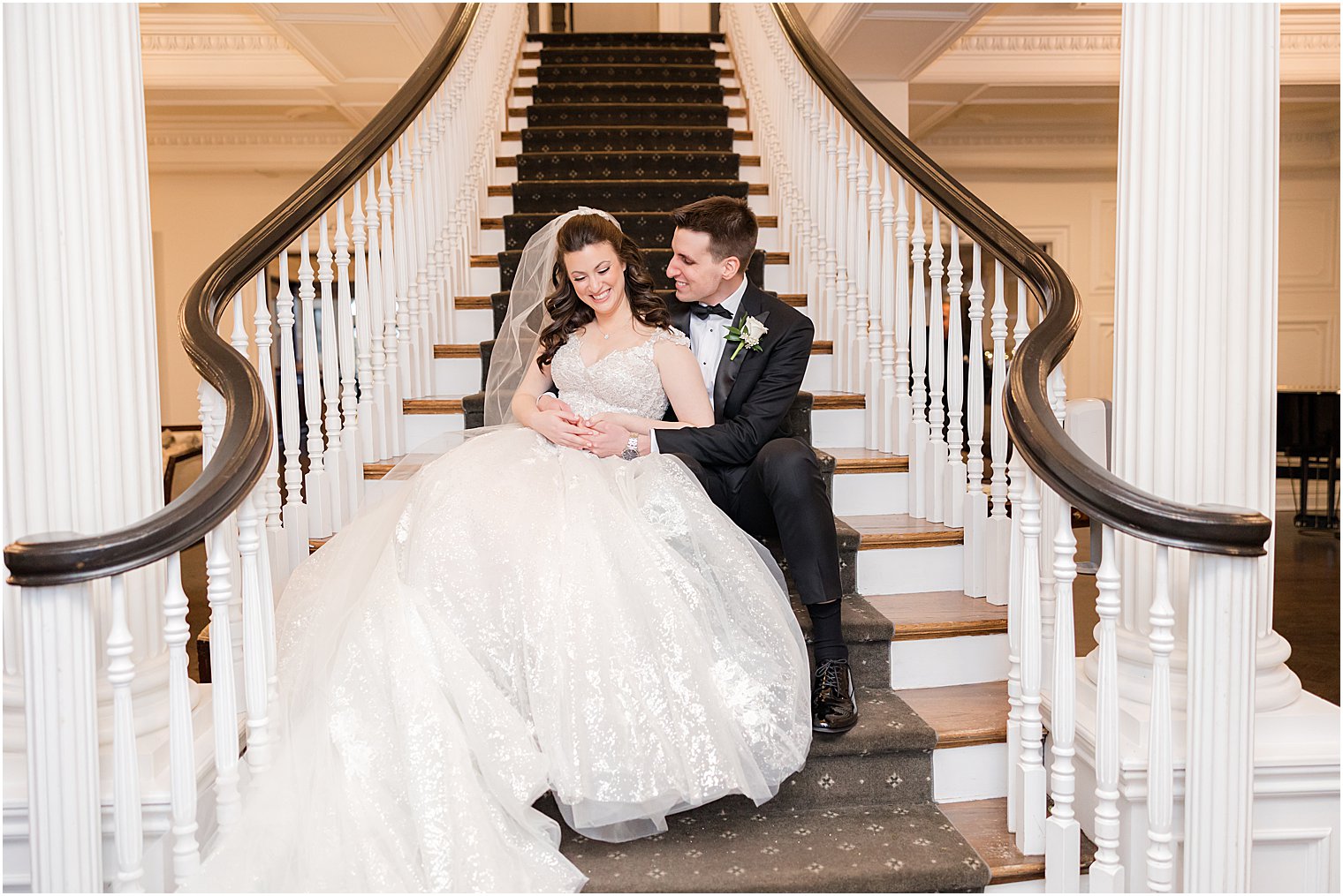 bride and groom laugh sitting on grand staircase inside Park Savoy Estate