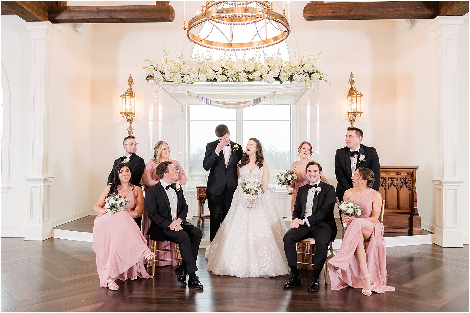 bride and groom laugh with wedding party in chapel at Park Savoy Estate