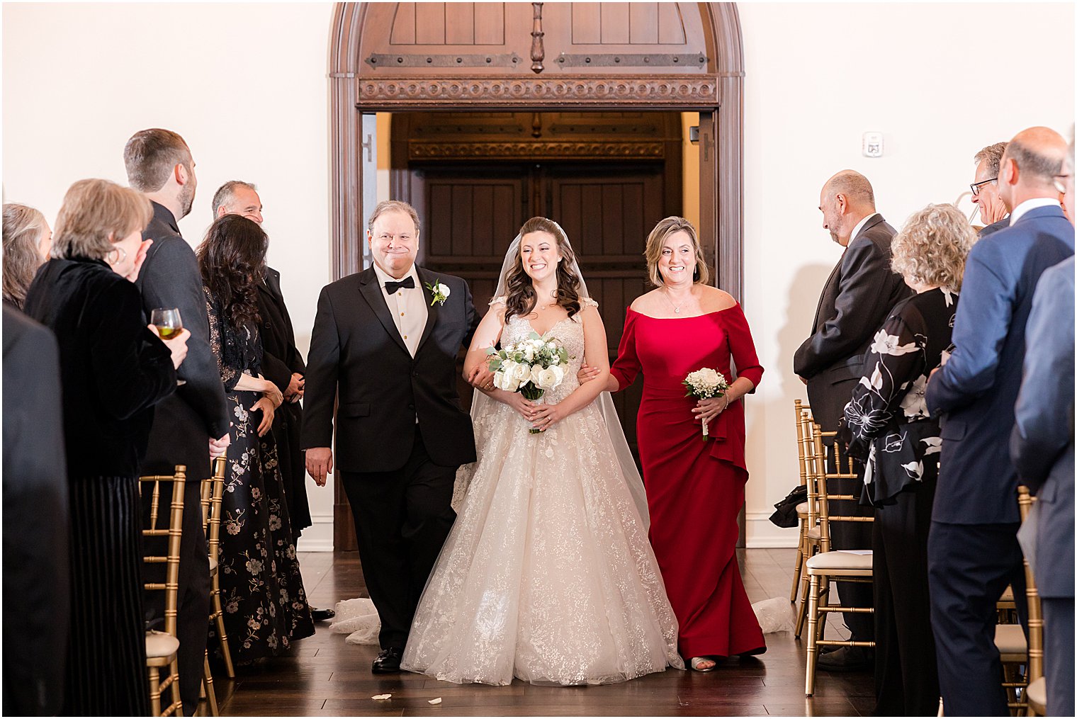 bride walks into ceremony at Park Savoy Estate with parents 