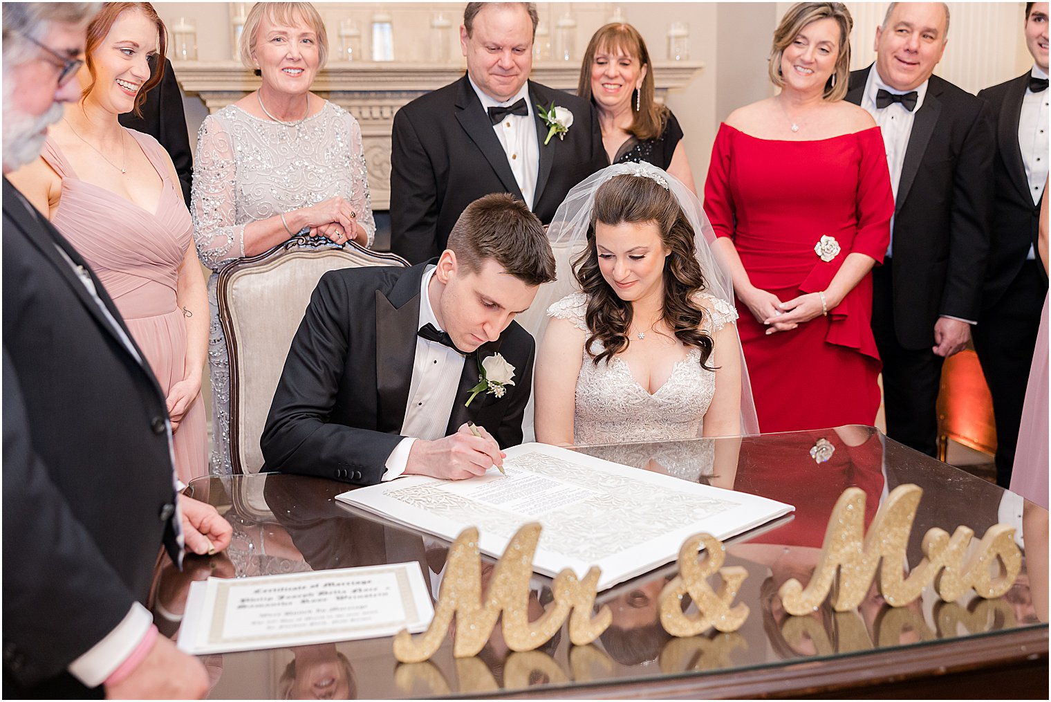 groom signs Ketubah during Jewish wedding ceremony 