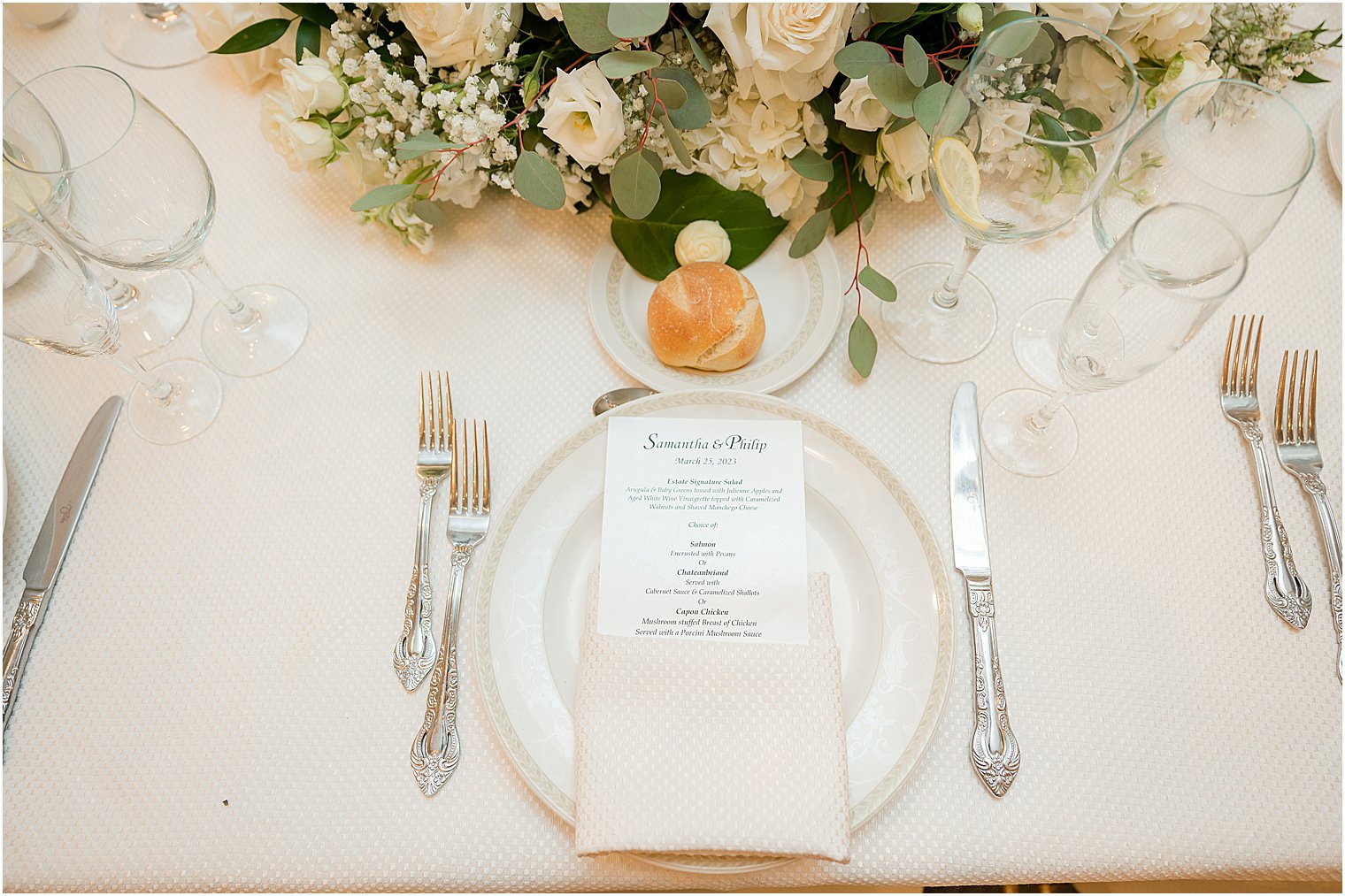 place setting with white plates, napkins and menu cards 