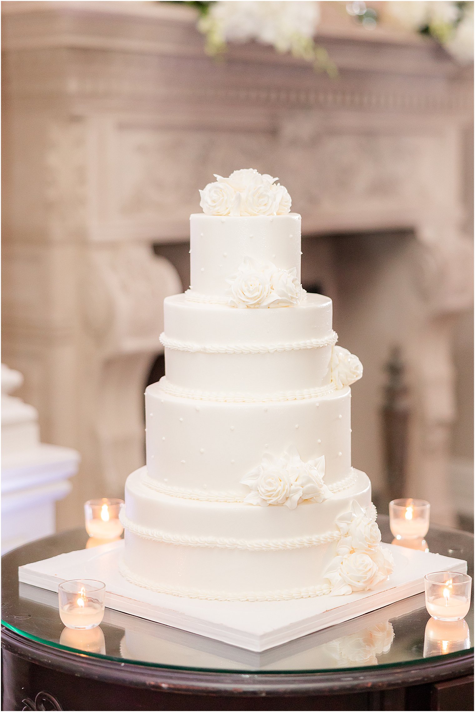 tiered wedding cake in all-white icing with flowers 