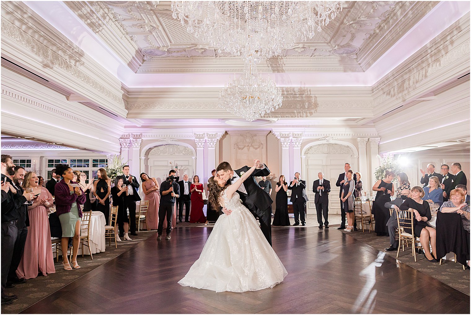 groom dips bride kissing her during first dance 