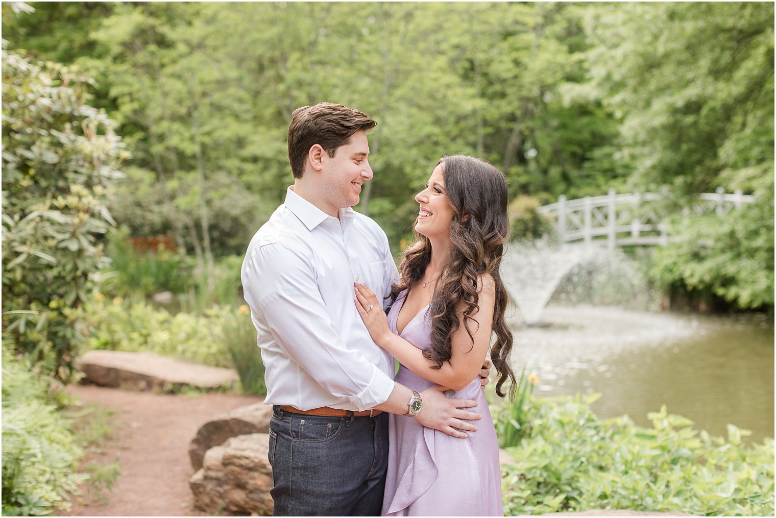 man in white shirt hugs woman in purple dress inside Sayen Gardens 