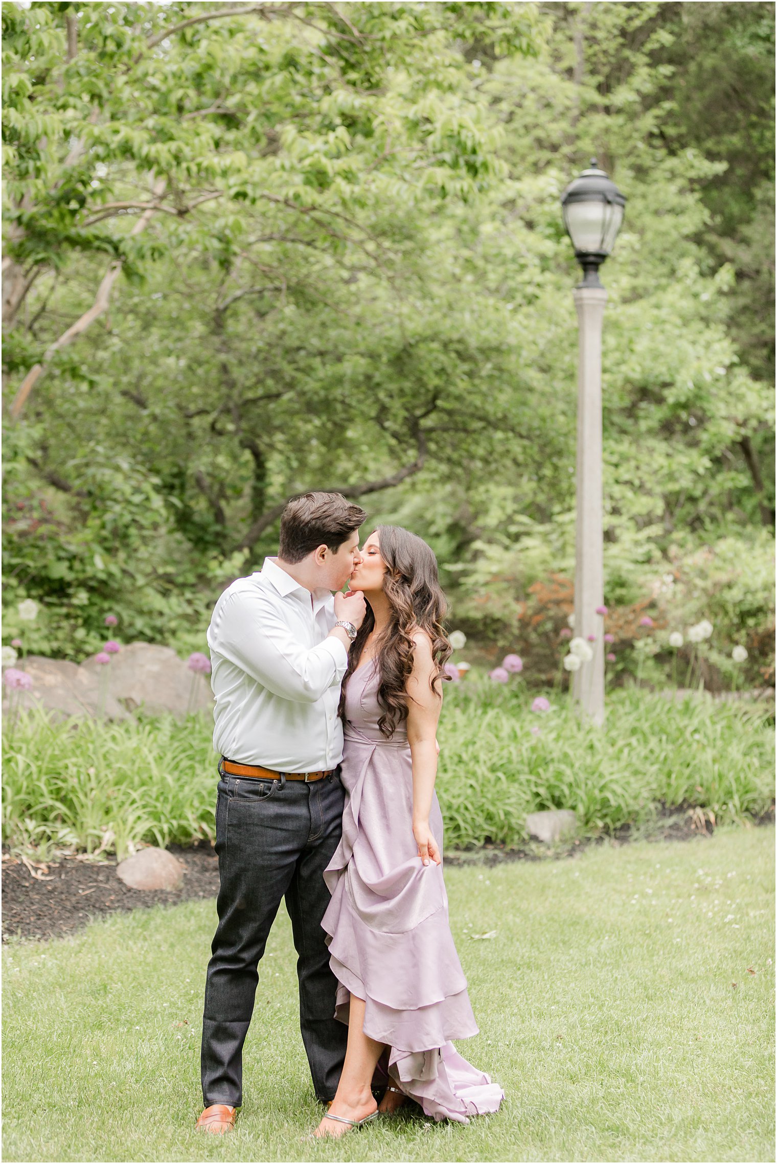 engaged couple kisses on lawn during Sayen Gardens engagement session