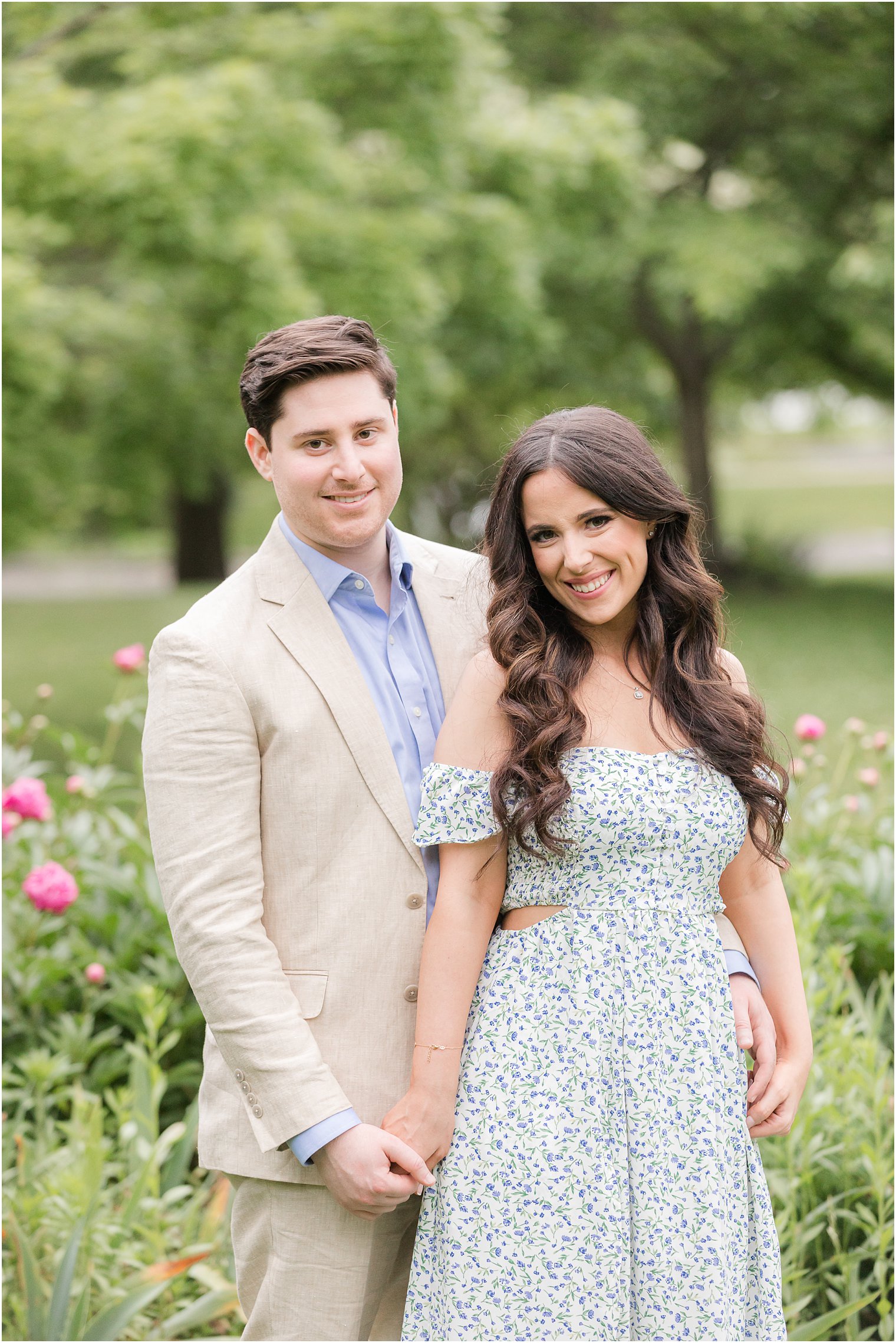 woman in blue dress holds hand with man standing behind her