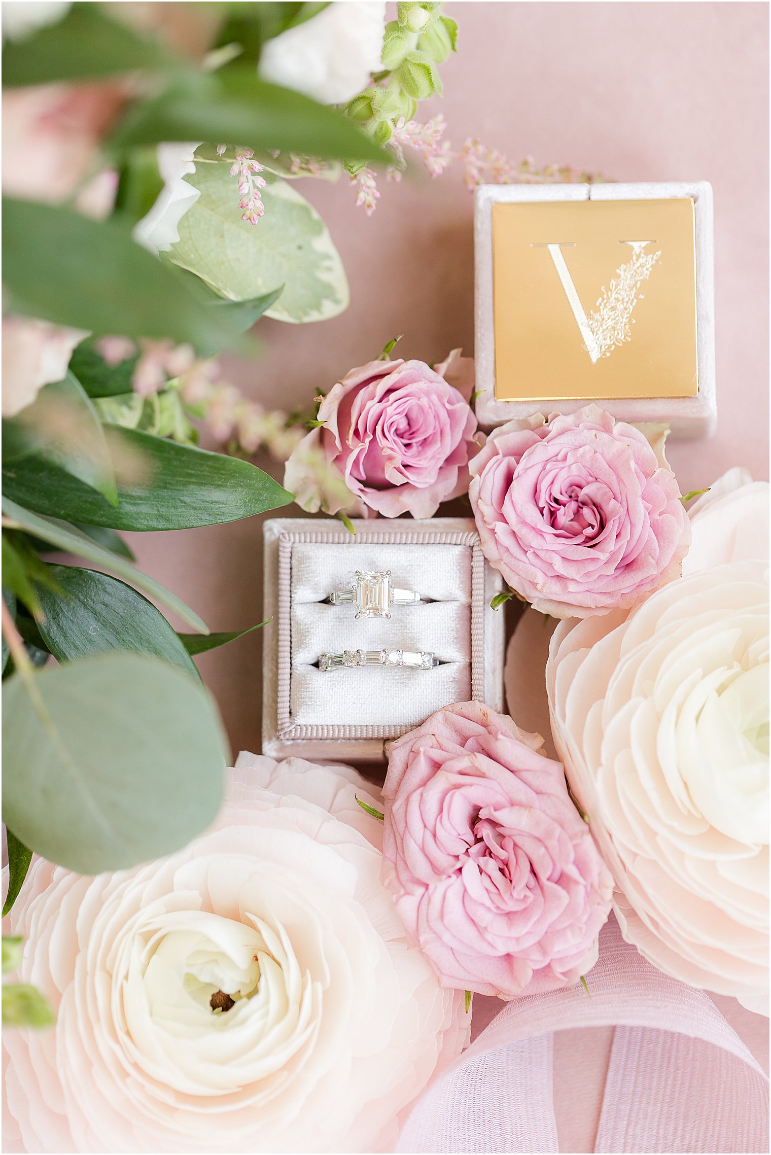 wedding rings in ivory box with red and white ranunculus 