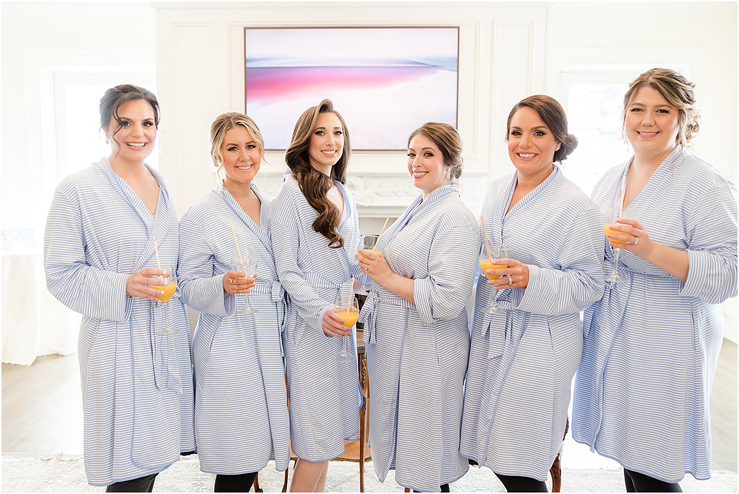 bride and bridesmaids pose in matching blue robes