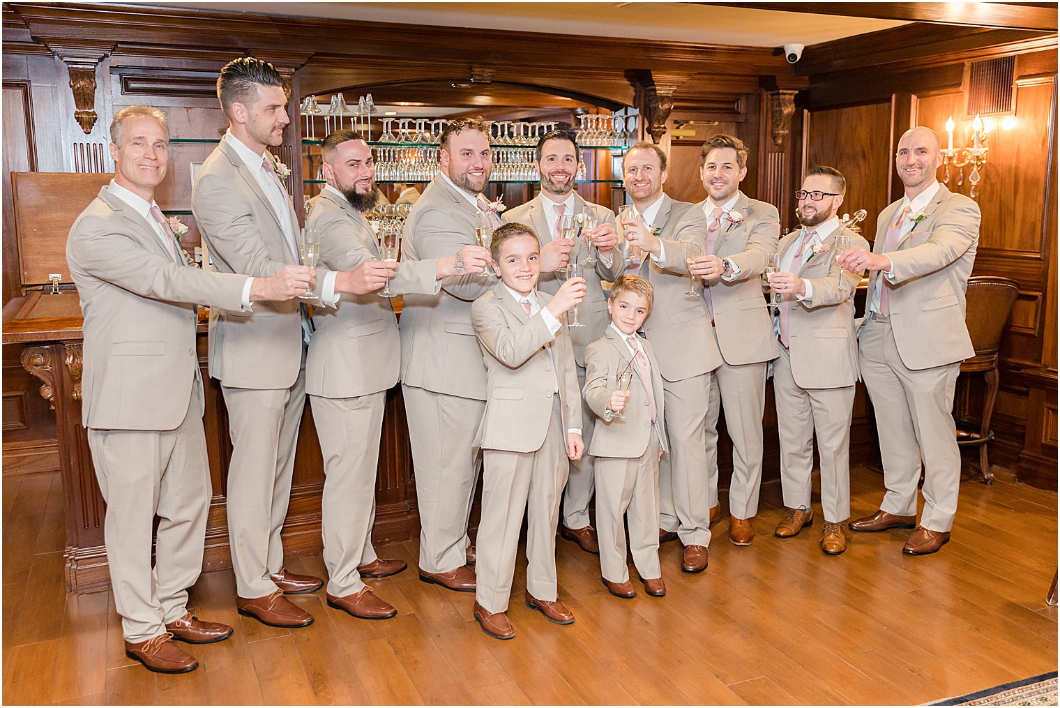 groom and groomsmen pose with ring bearers in tan suit at Park Savoy Estate