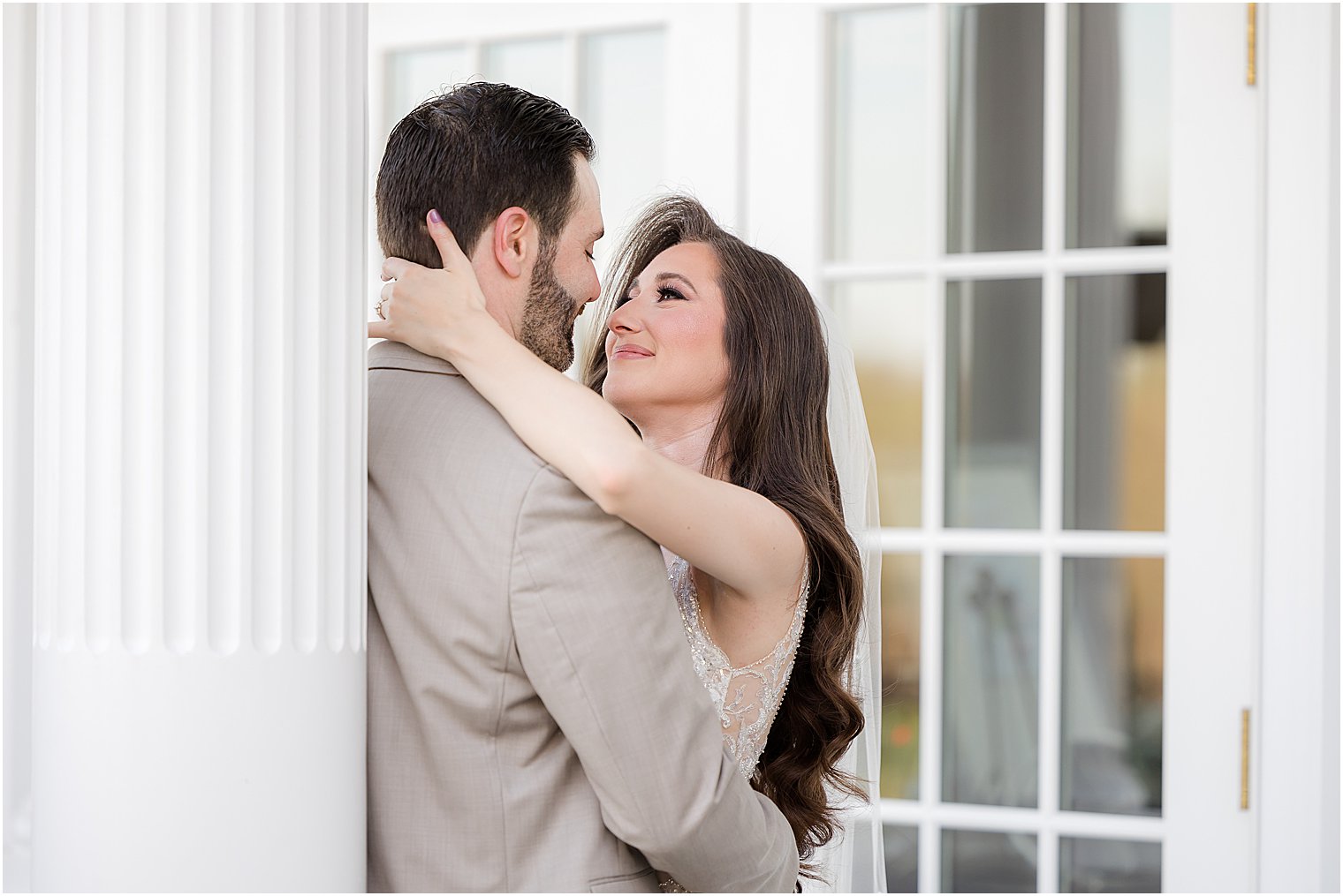 bride and groom hug near column at Park Savoy Estate