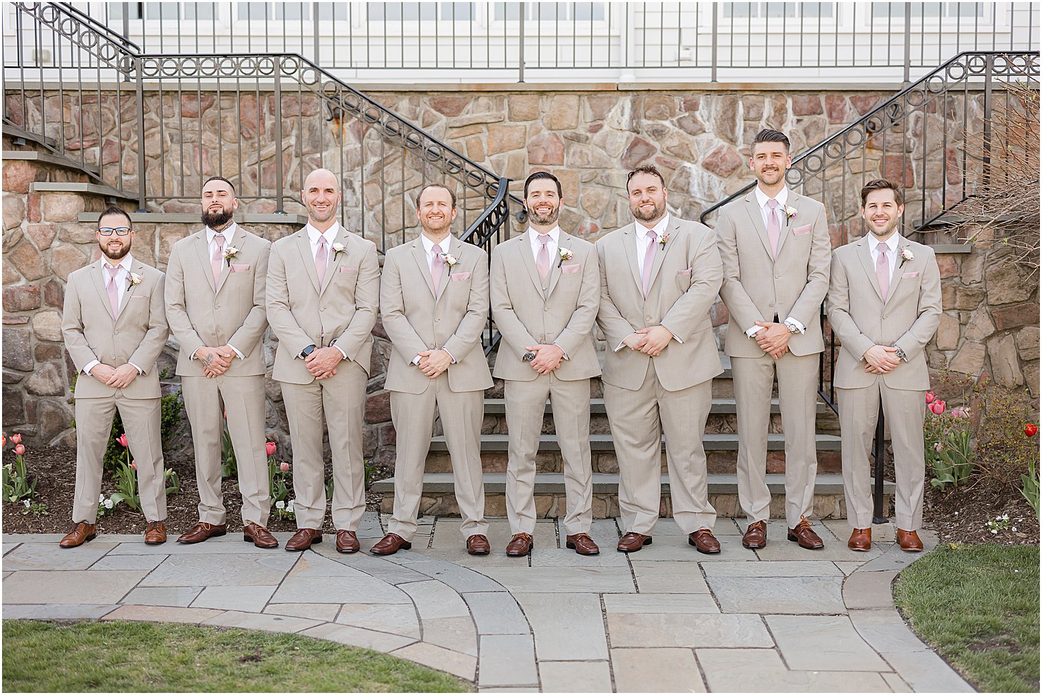 groom stands in line with groomsmen in tan suits at Park Savoy Estate