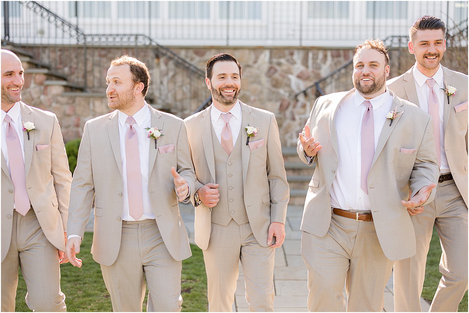 groom walks with groomsmen in tan suits