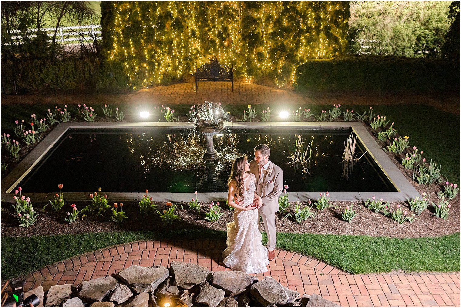 bride and groom hug in gardens at Park Savoy Estate at night
