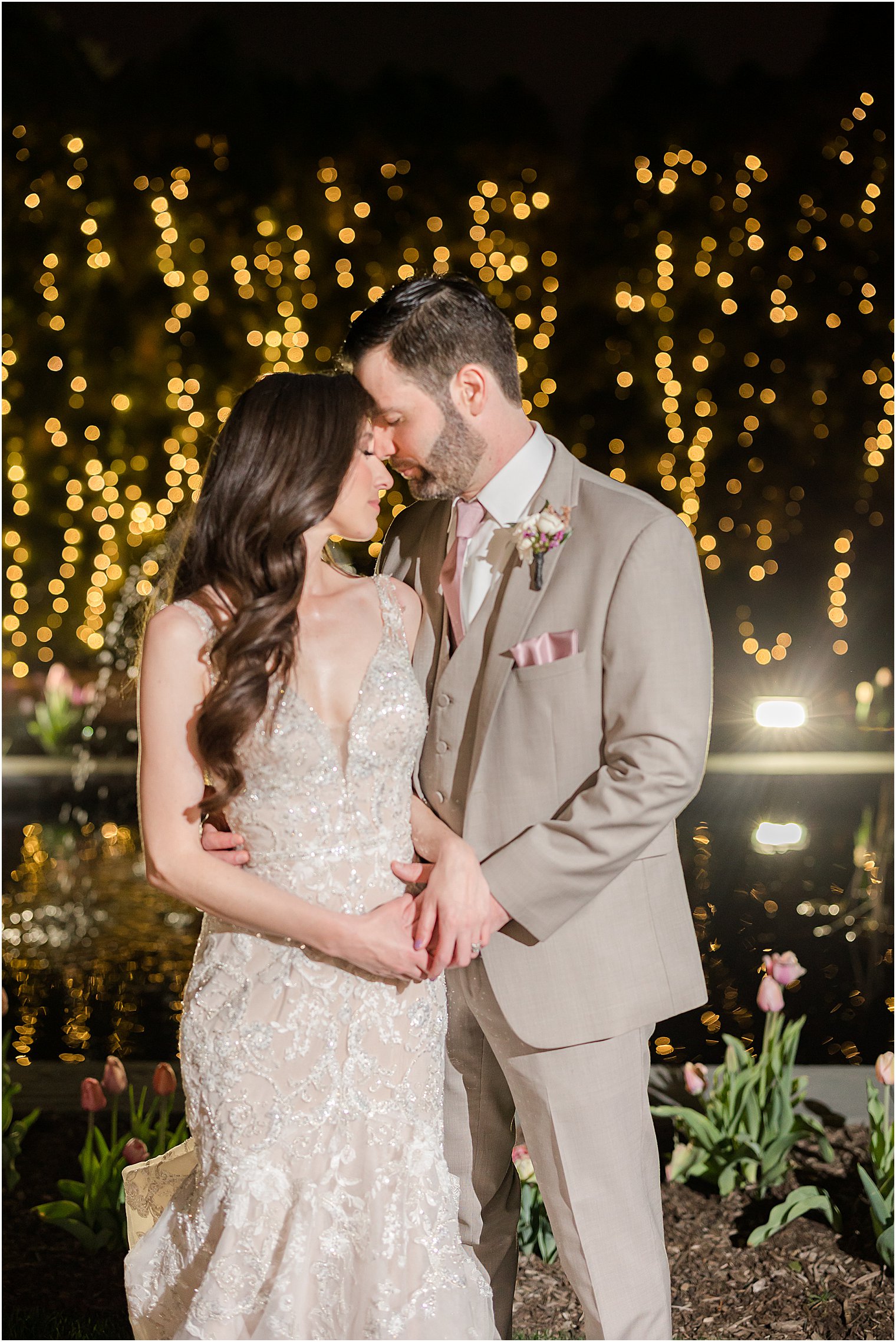 bride and groom hug in gardens at Park Savoy Estate at night