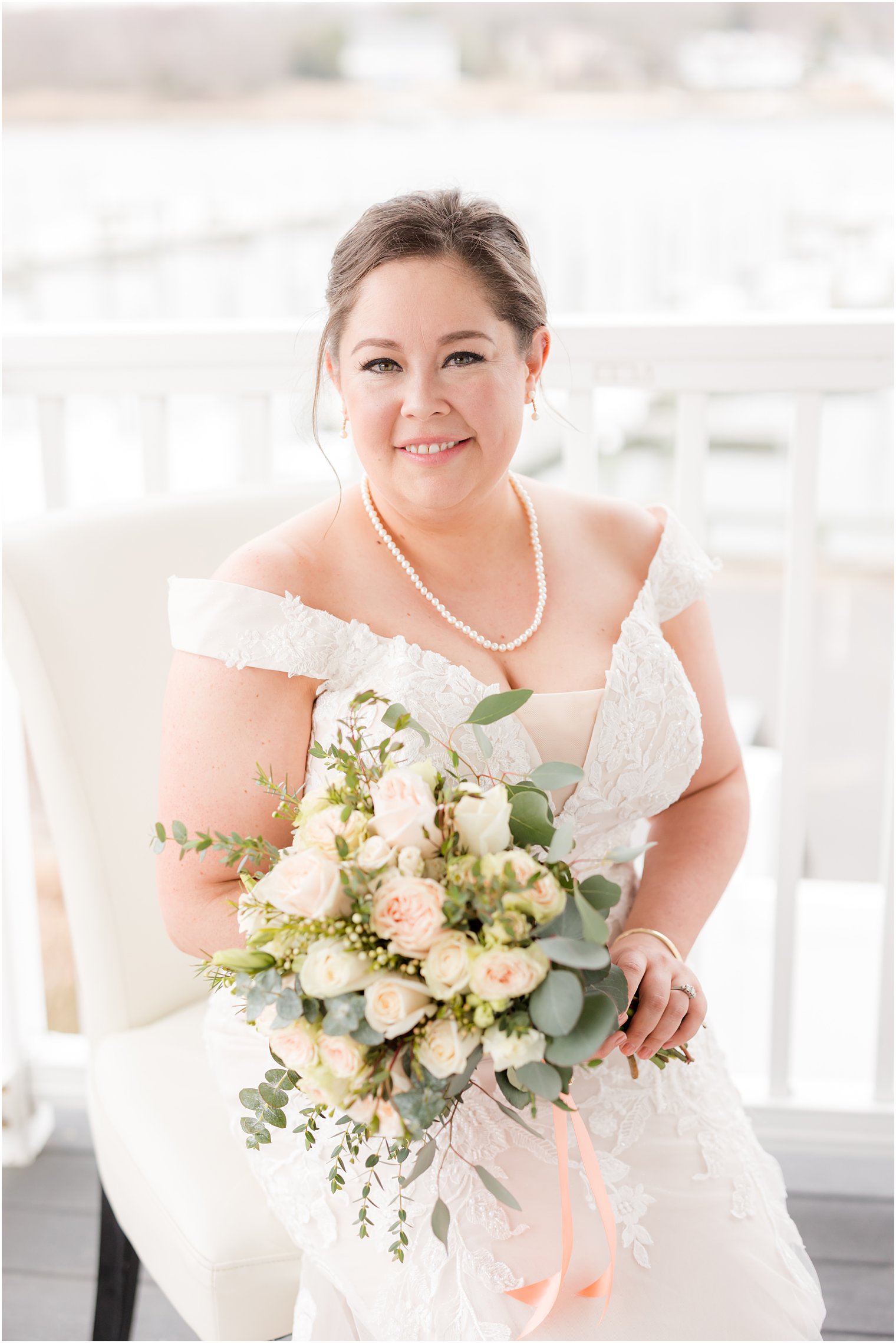 bride holds bouquet of white and pink roses 