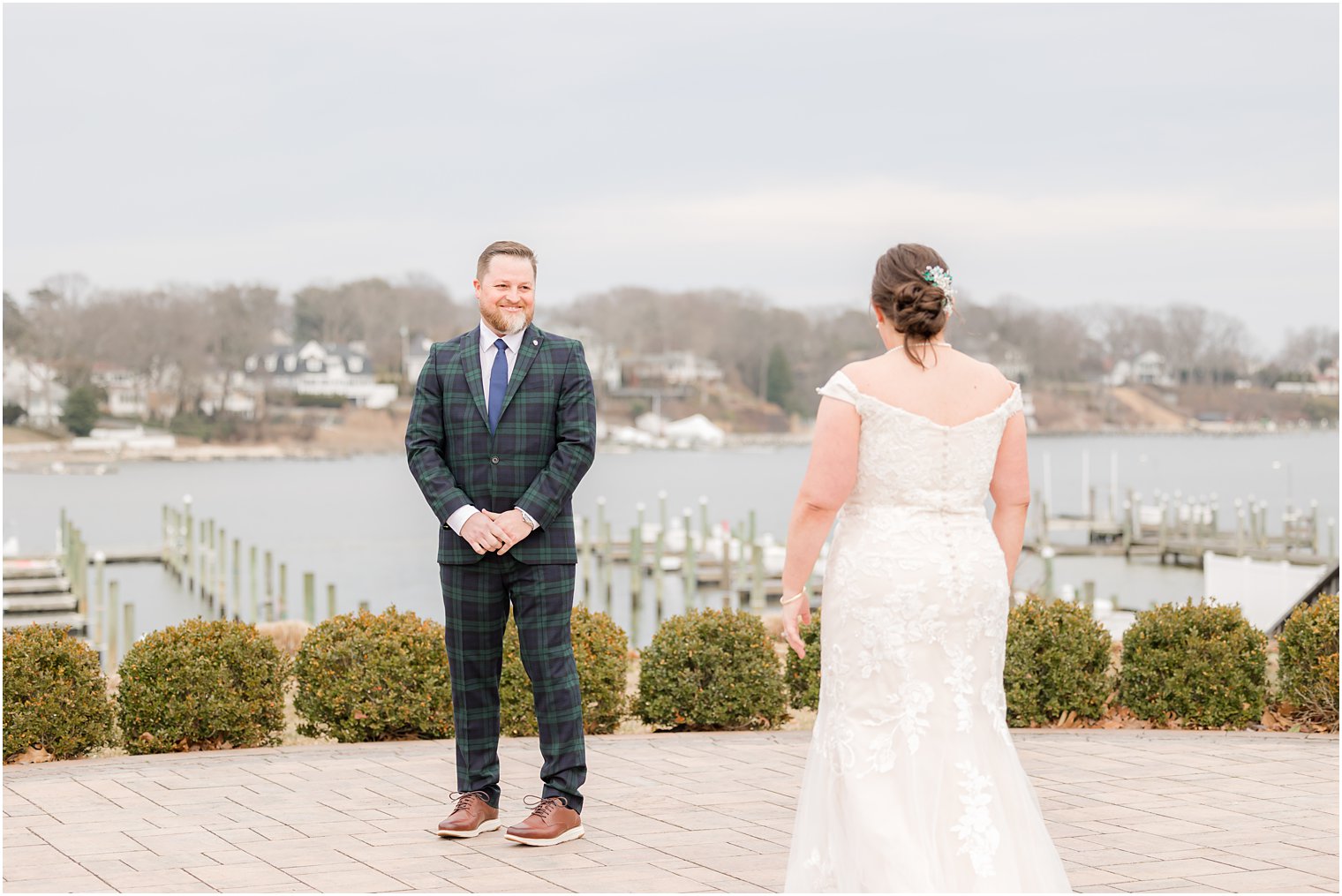 bride walks to meet groom for first look on patio at Crystal Point Yacht Club