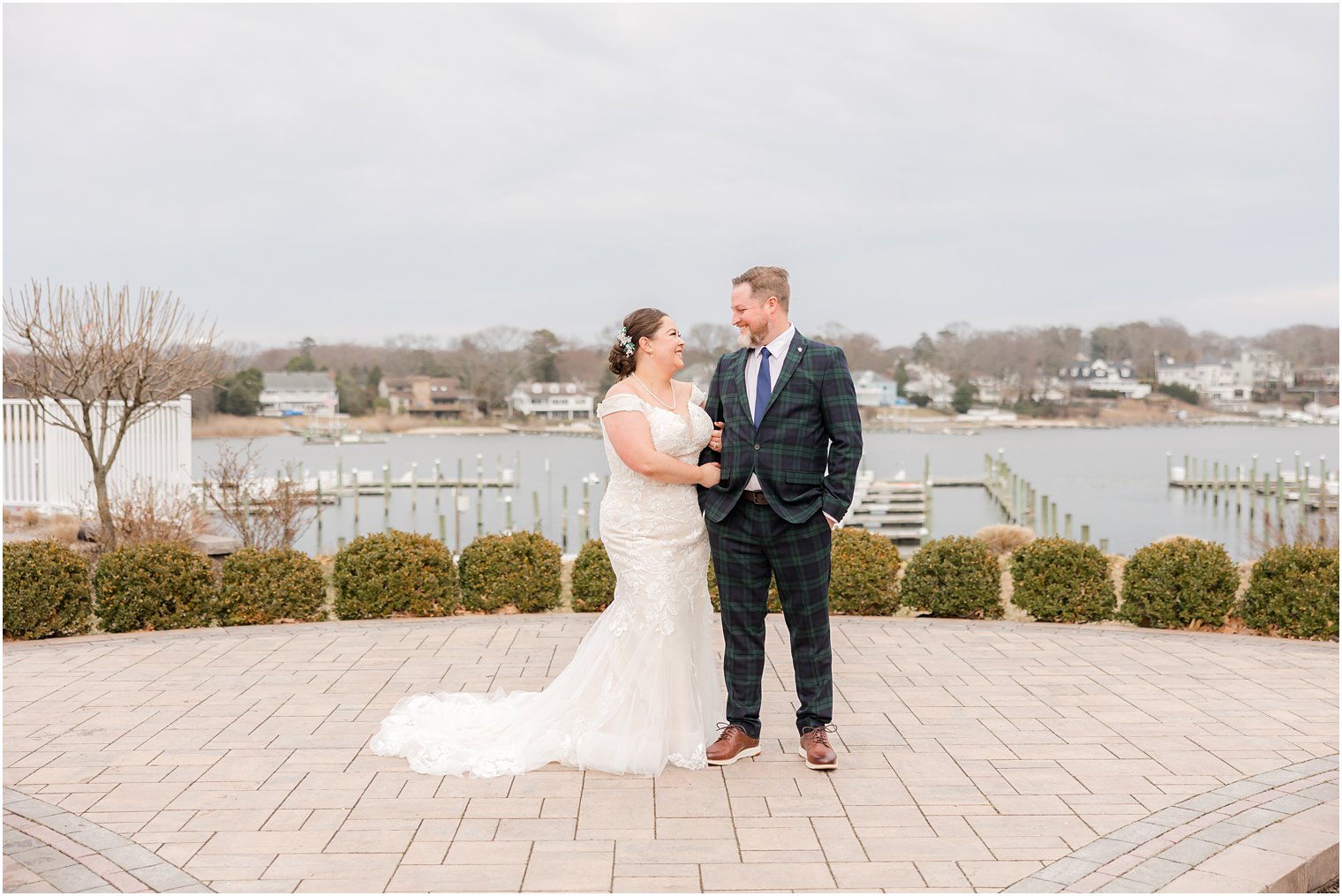 bride looks up at groom in plaid suit at Crystal Point Yacht Club