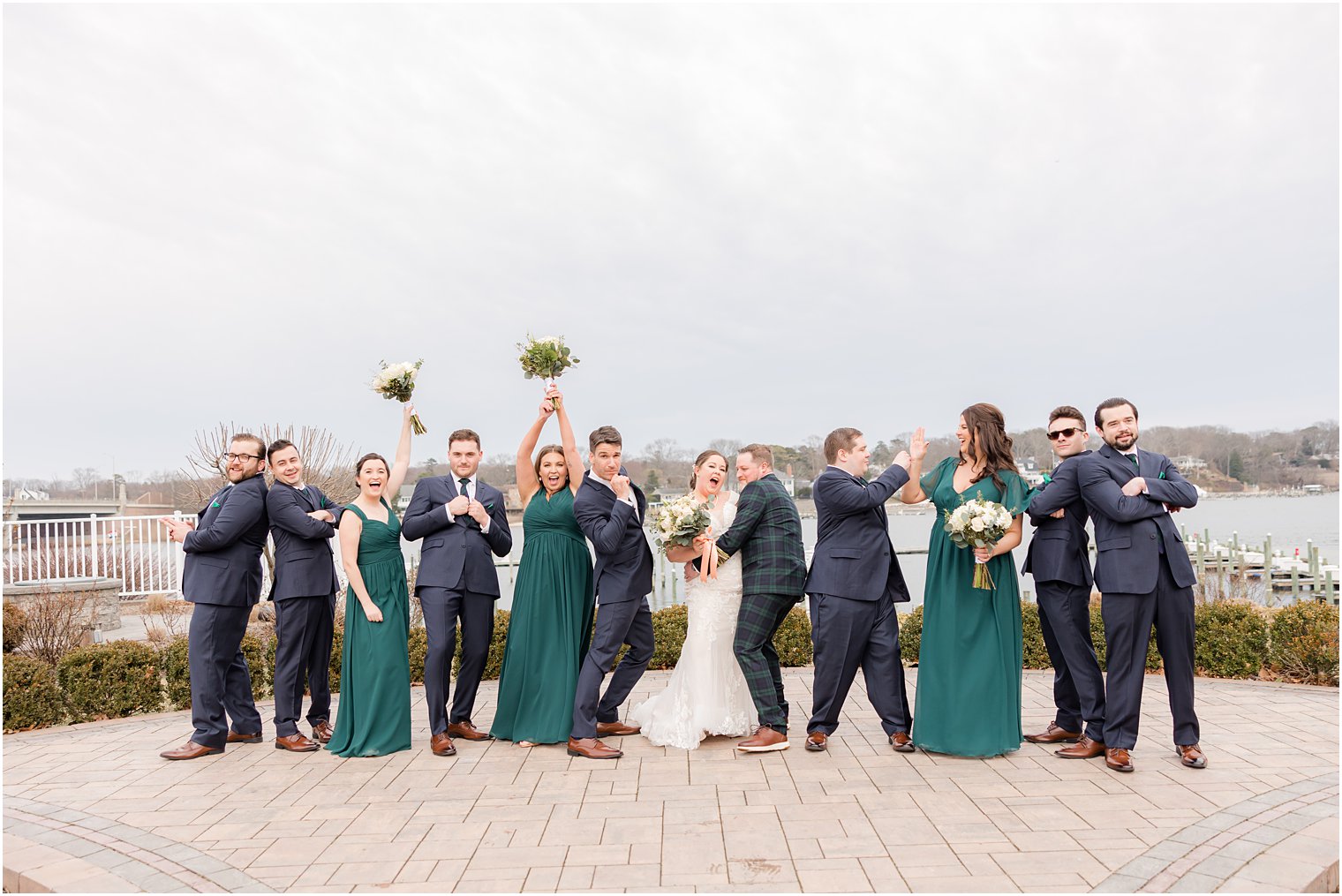 bride and groom kiss while wedding party cheers on patio at Crystal Point Yacht Club