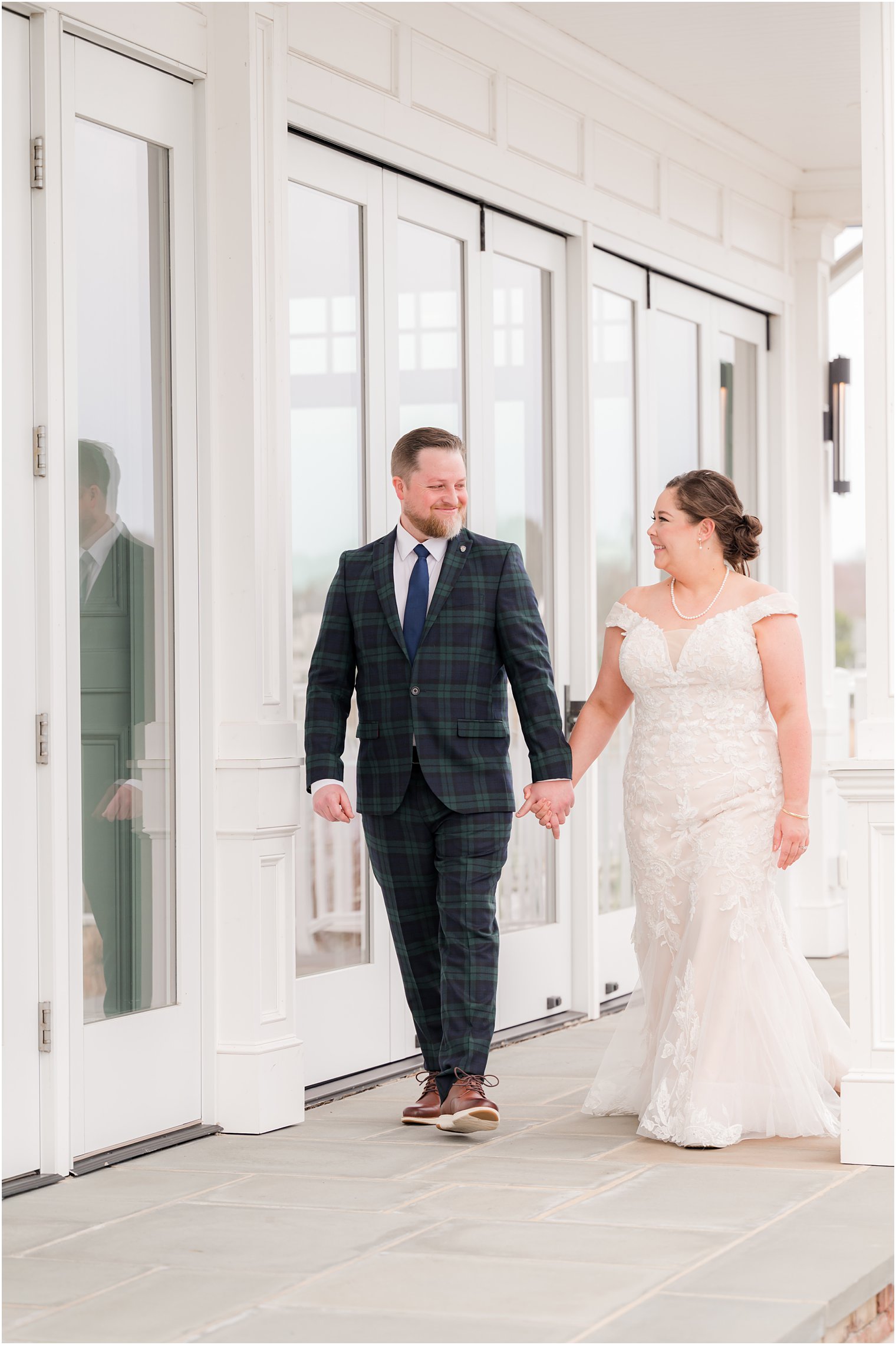 bride and groom hold hands walking down patio at Crystal Point Yacht Club