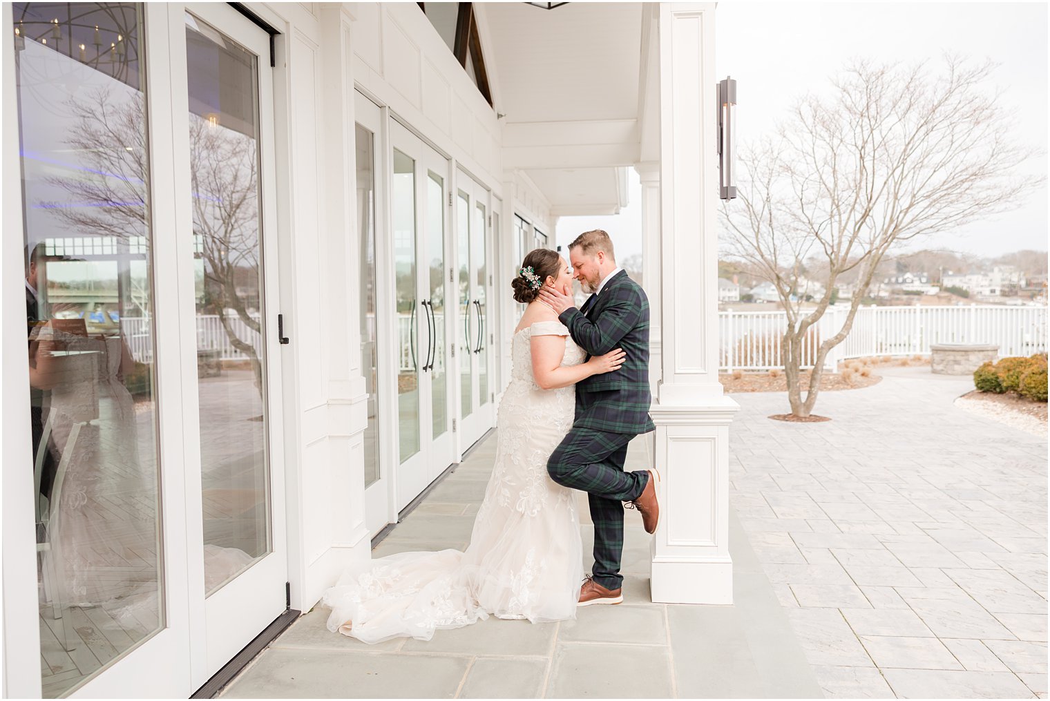 bride and groom kiss outside Crystal Point Yacht Club