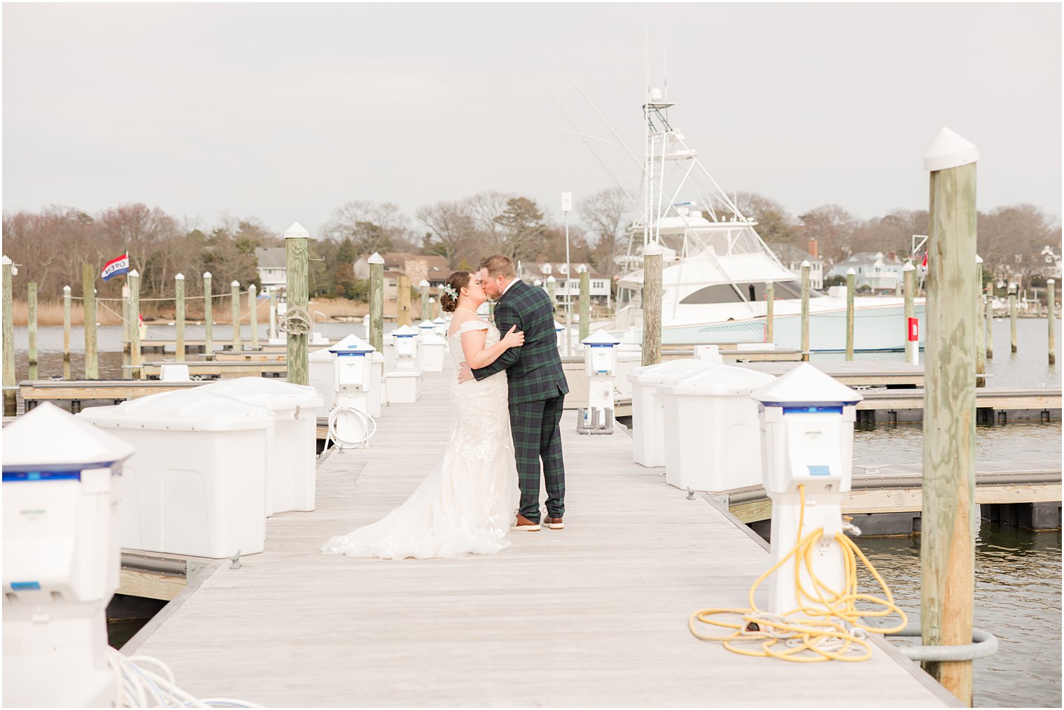 newlyweds kiss on pier at Crystal Point Yacht Club