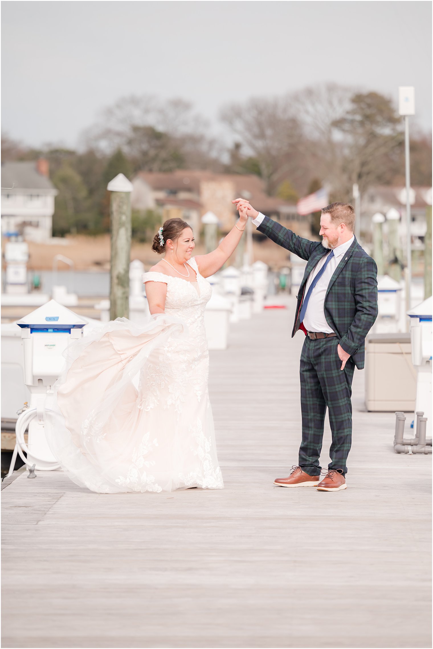 groom twirls bride on pier at Crystal Point Yacht Club