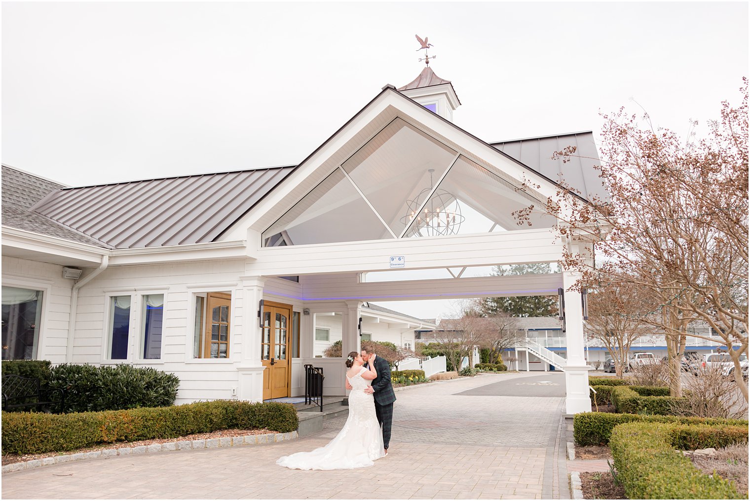 bride and groom hug under arbor at Crystal Point Yacht Club