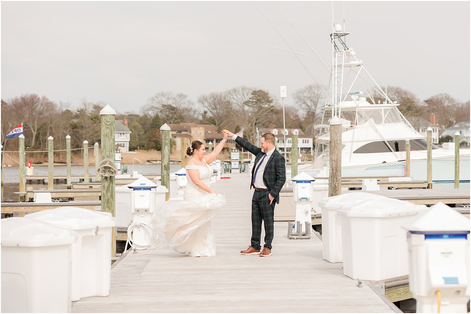 groom twirls bride between boats at marina near Crystal Point Yacht Club