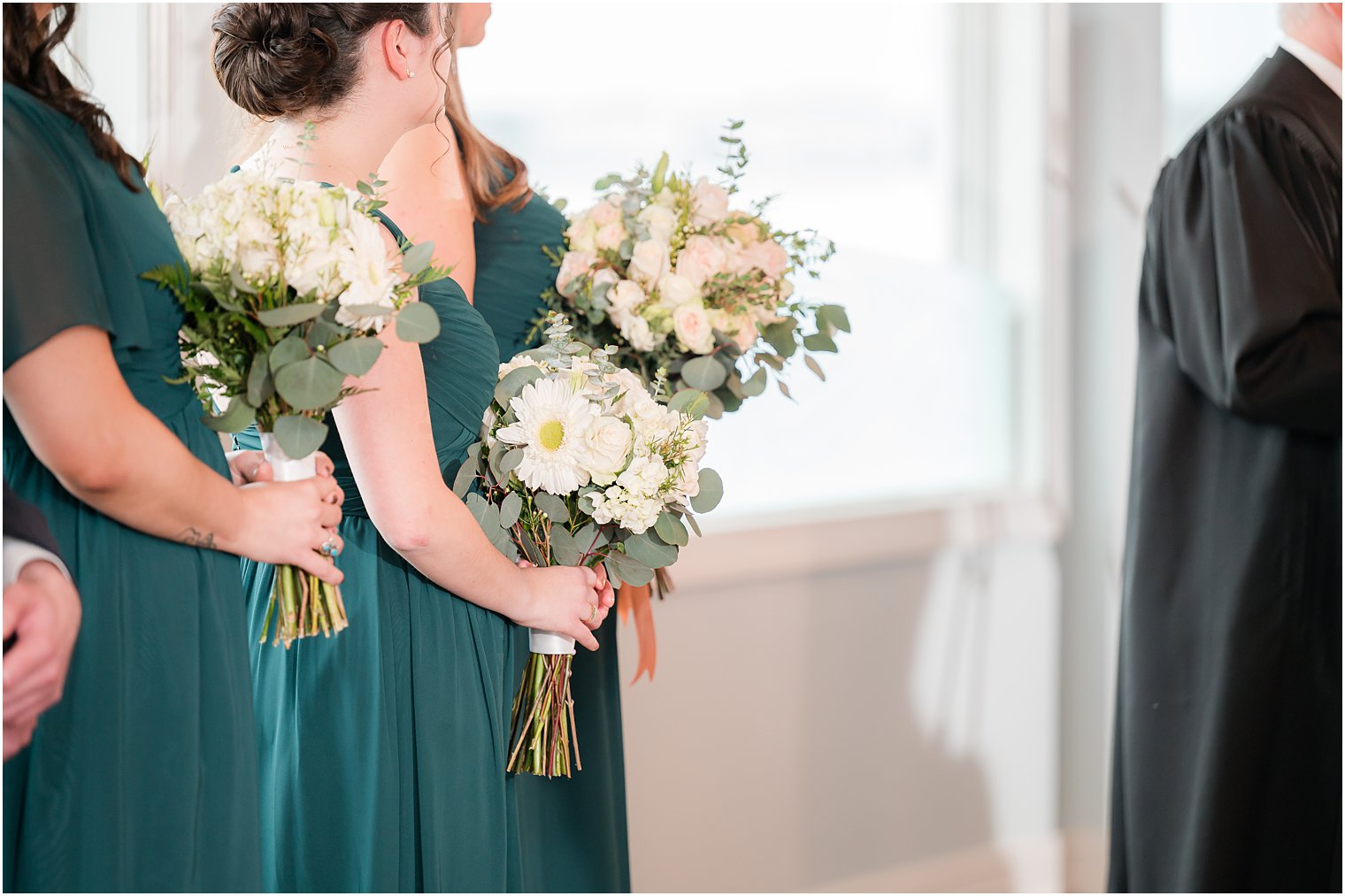 bridesmaids in teal gowns with white flowers at Crystal Point Yacht Club