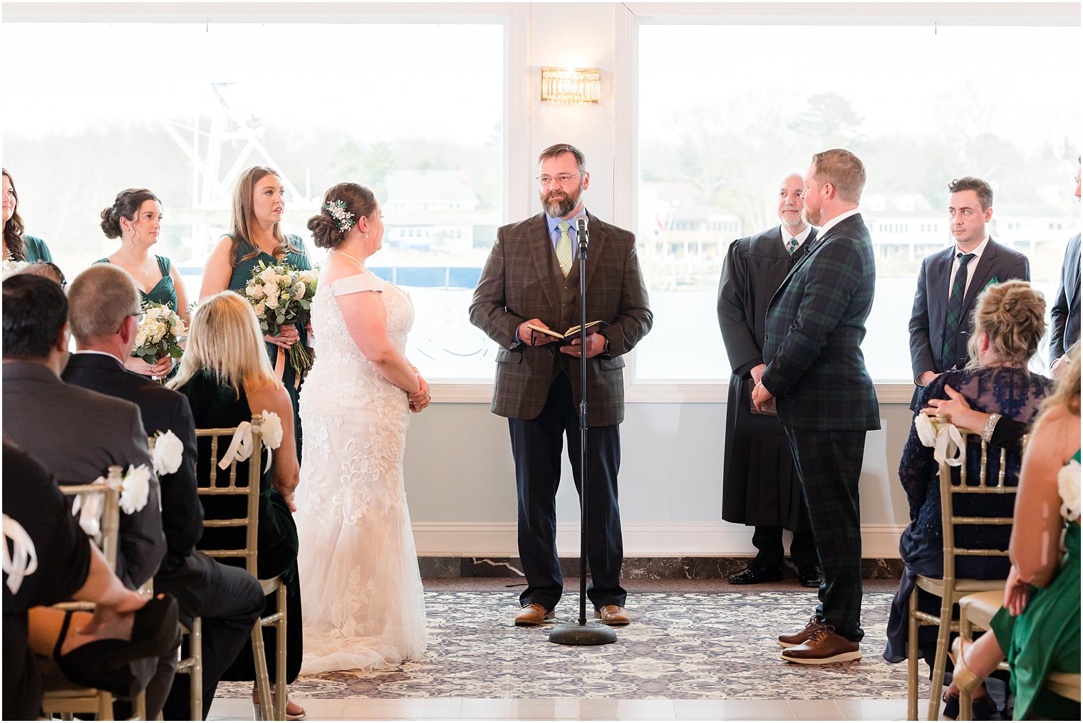 bride and groom exchange vows during wedding ceremony with waterfront views at Crystal Point Yacht Club