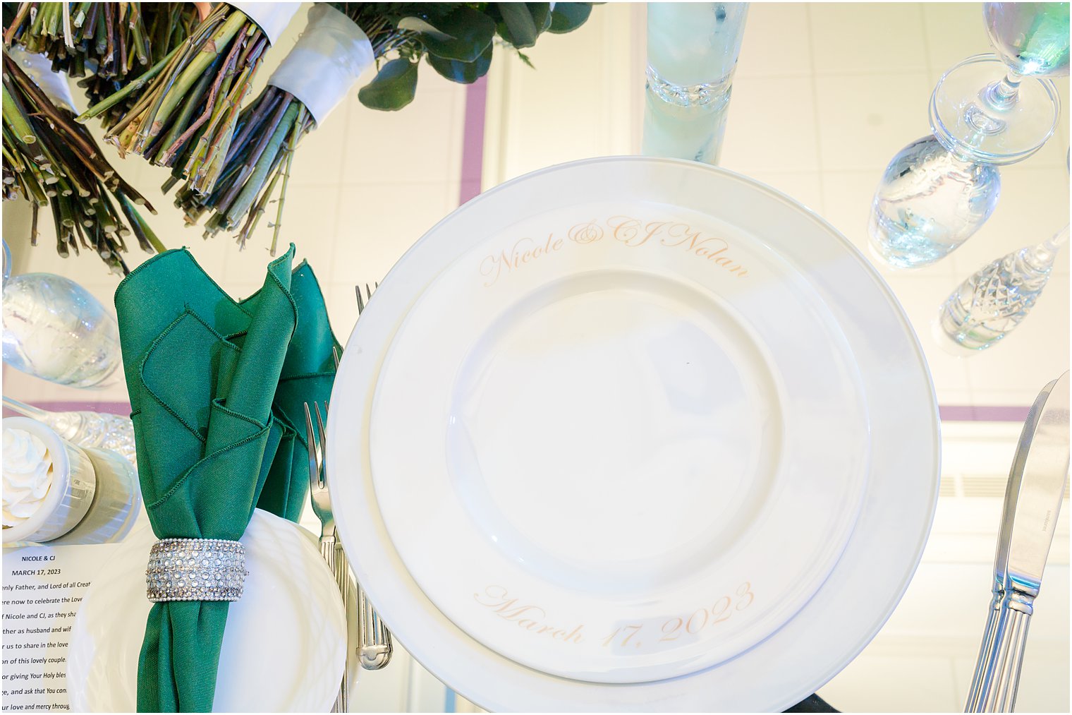 place setting with green napkin and white and gold plates 