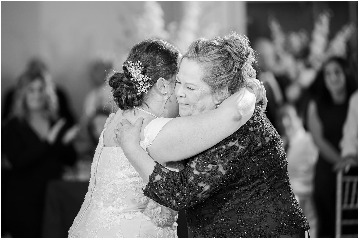 bride hugs mom during Crystal Point Yacht Club wedding reception 