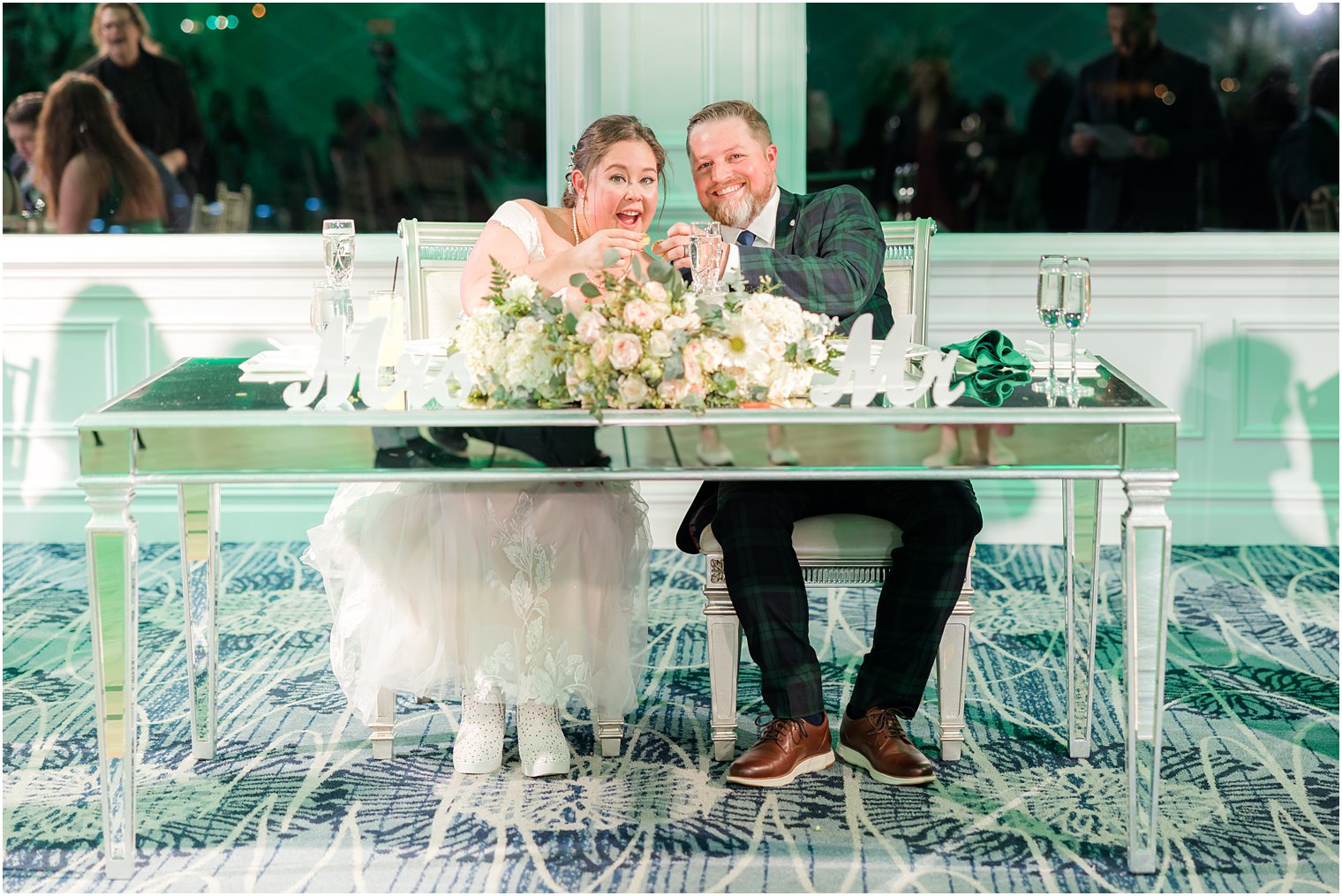 newlyweds sit at sweetheart table at Crystal Point Yacht Club