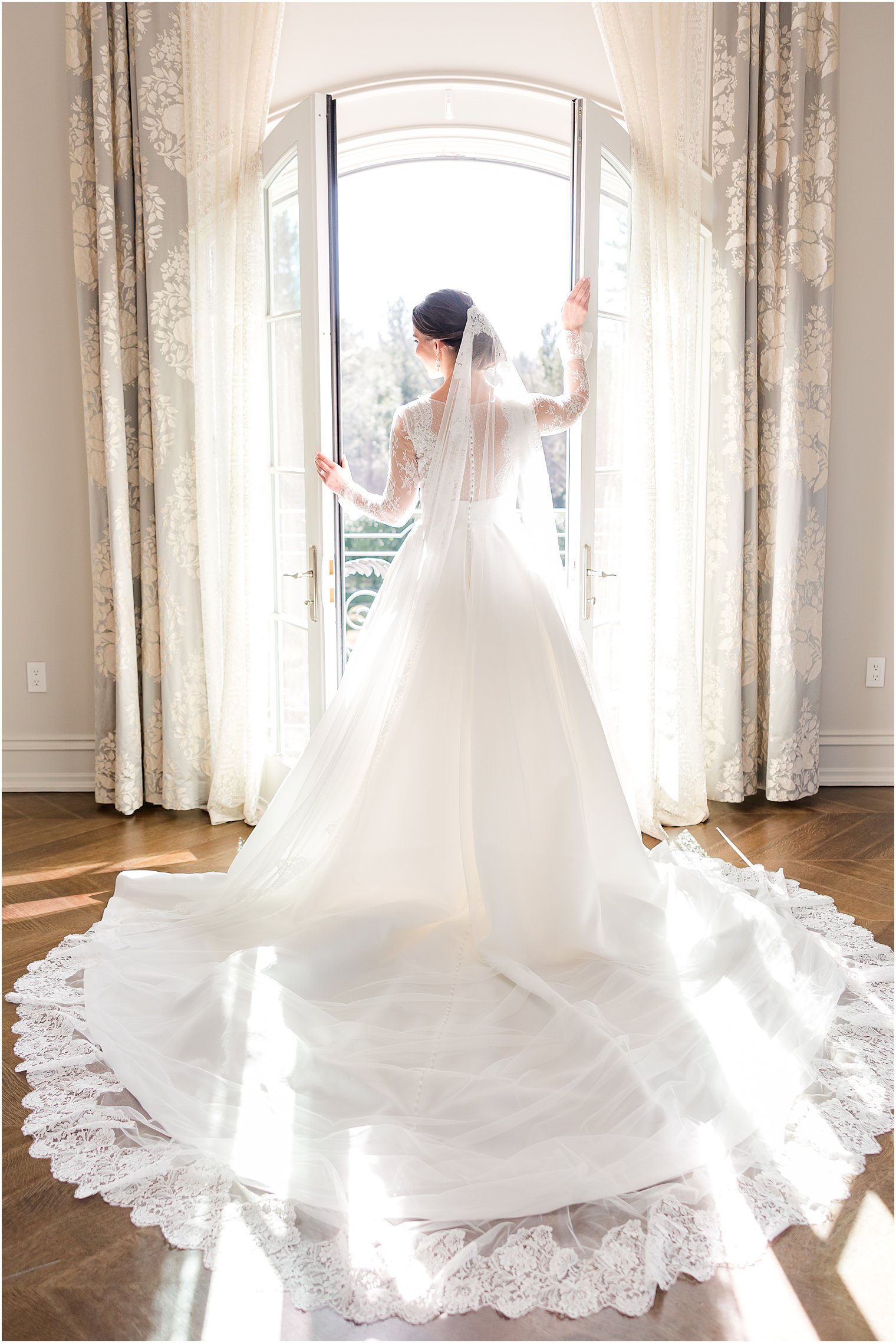 bride stands in window at Park Chateau Estate leaning against window frame 