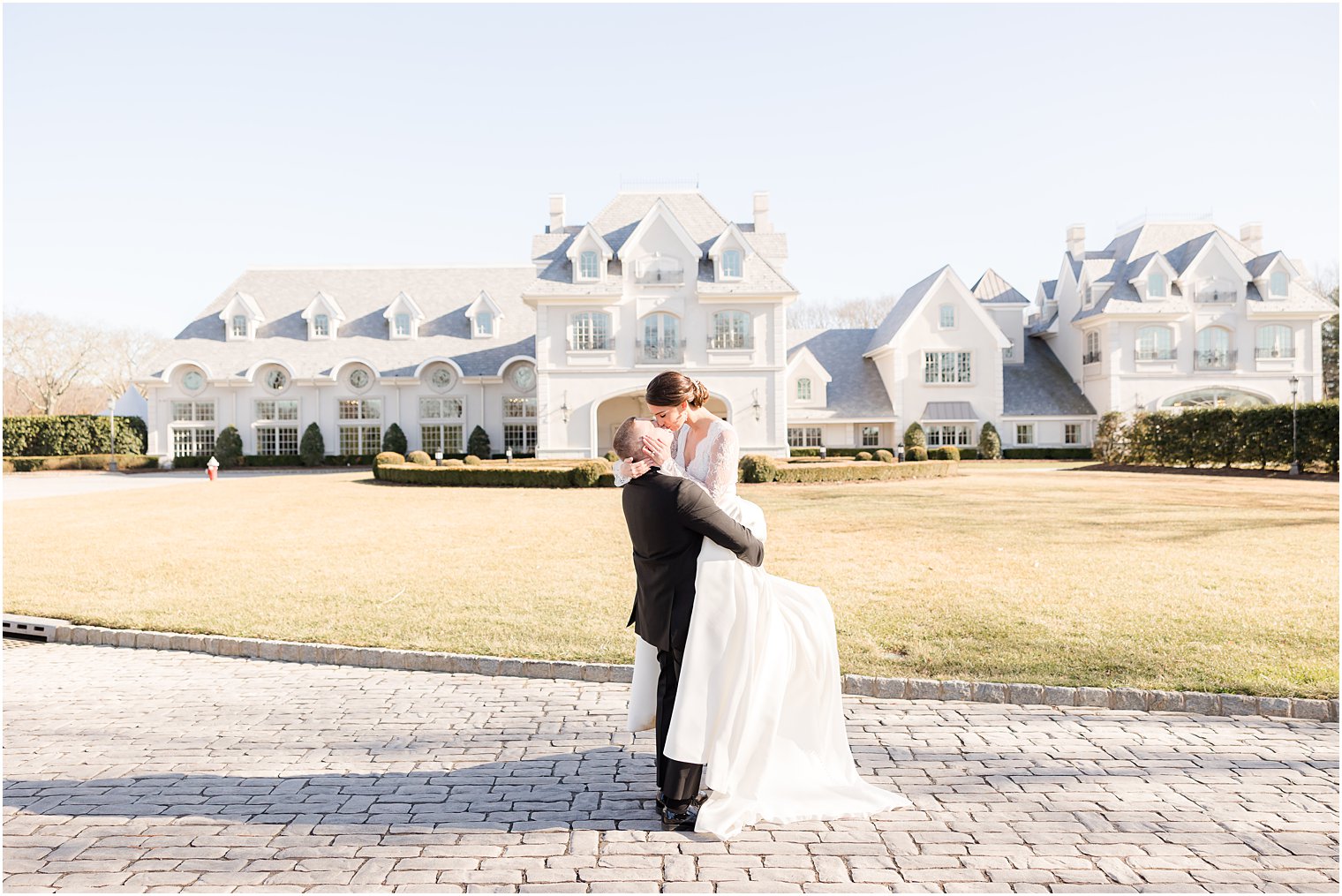 groom lifts bride off ground in front of Park Chateau Estate