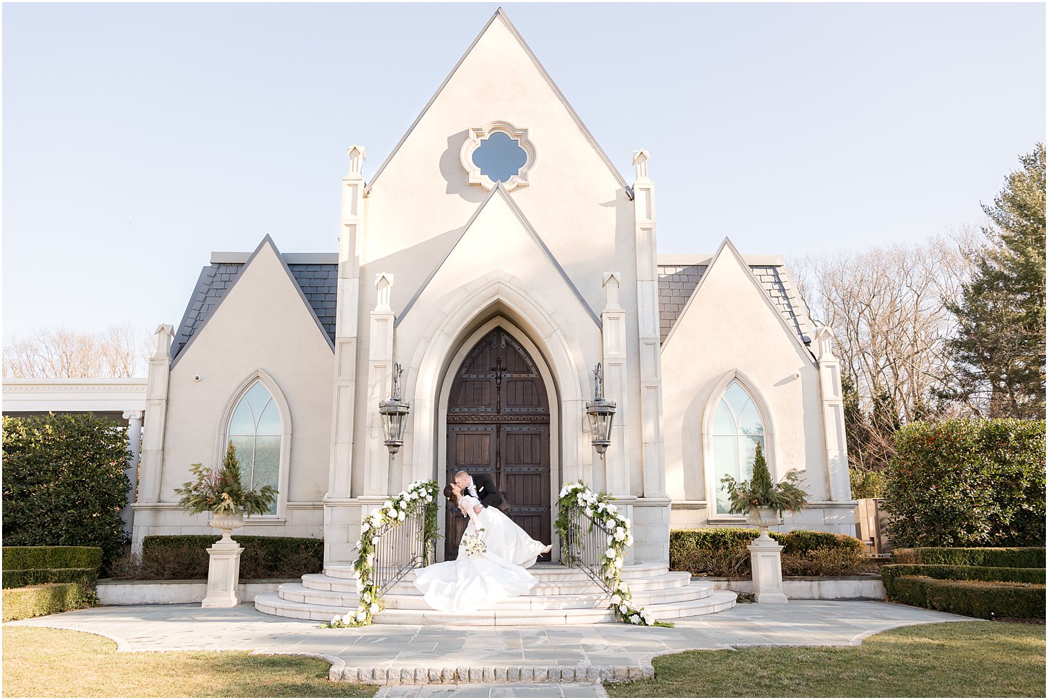 groom dips bride kissing her on steps of Park Chateau Estate's chapel 