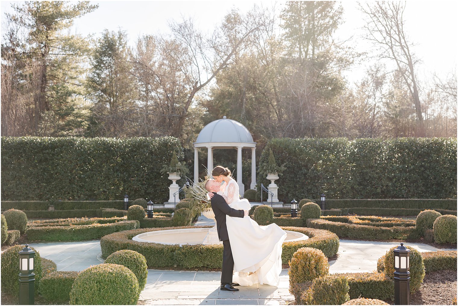 groom lifts bride in gardens of Park Chateau Estate