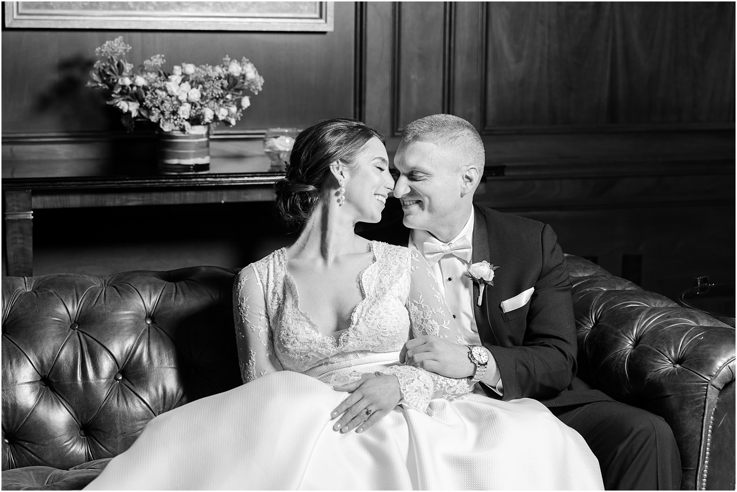 bride and groom sit on leather chair in library at Park Chateau Estate