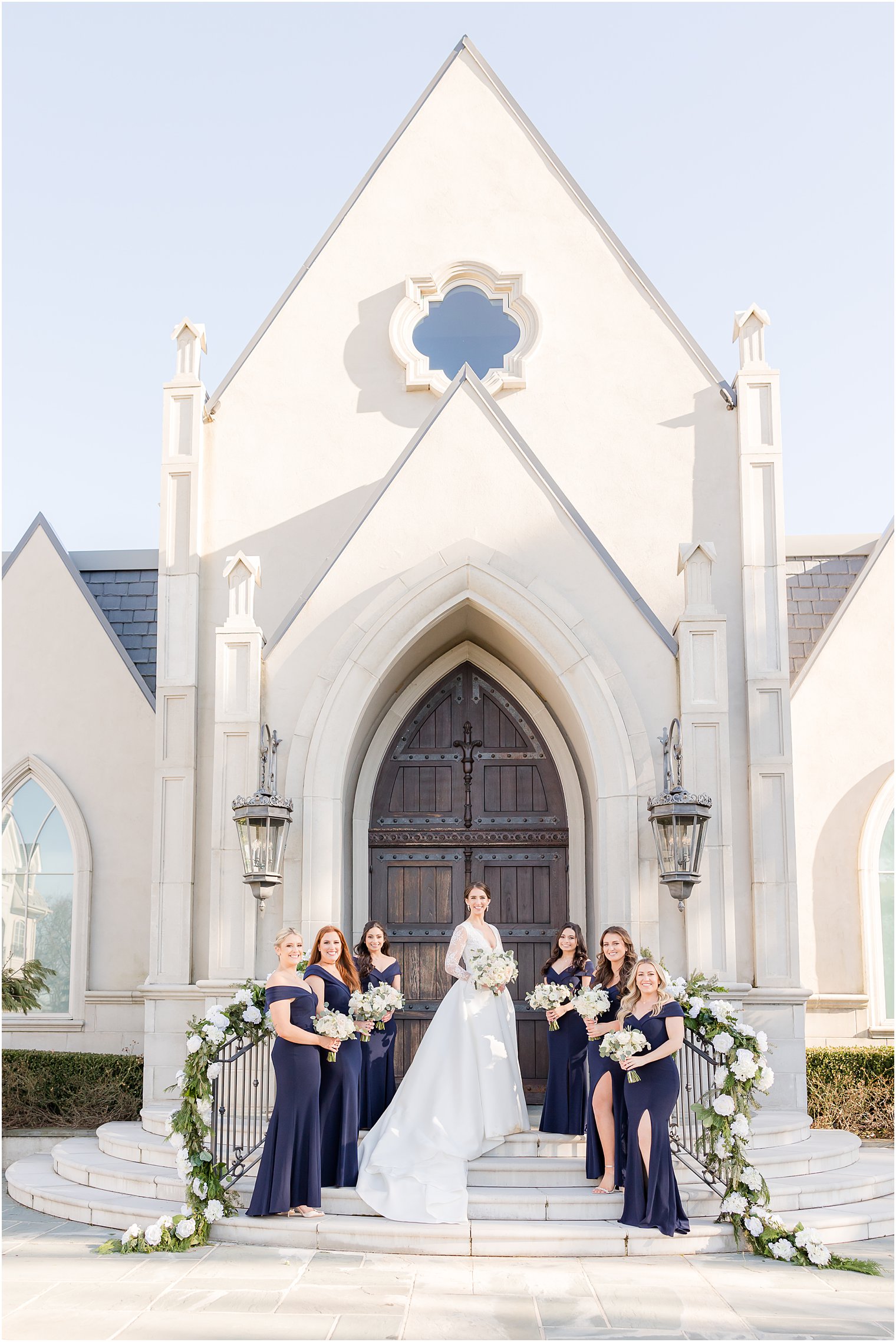 bride and bridesmaids stand on steps outside Park Chateau Estate's chapel