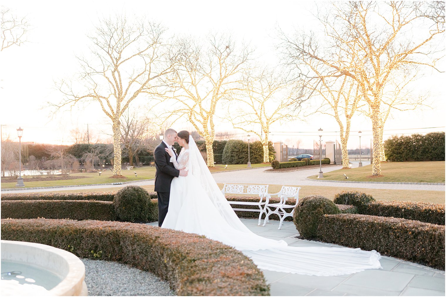 newlyweds hug in gardens at sunset outside Park Chateau Estate