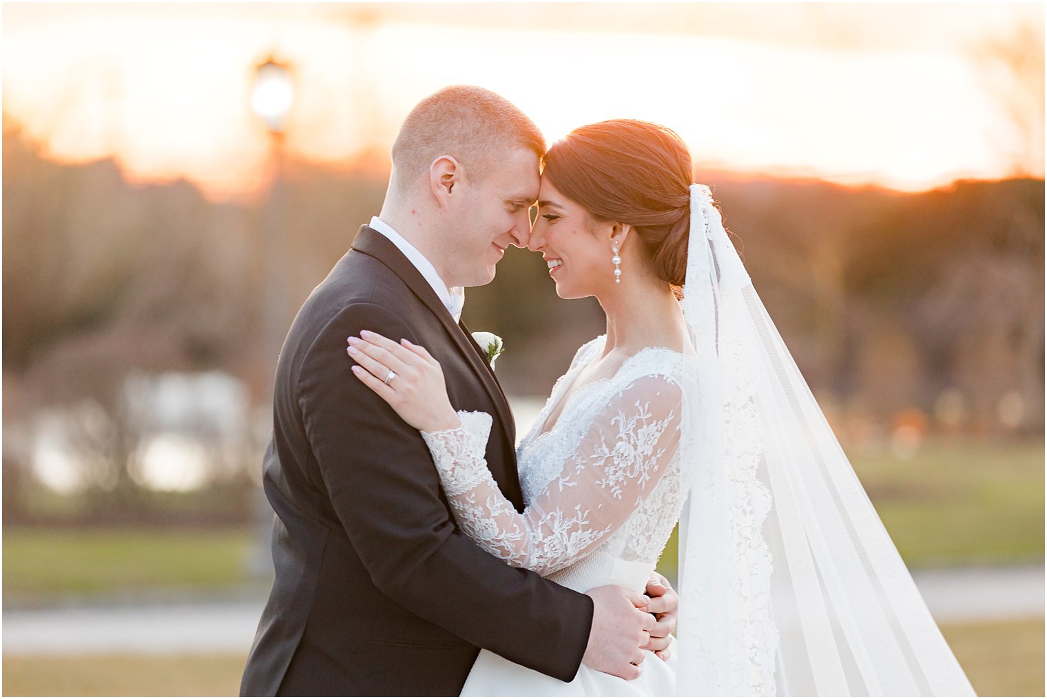 bride and groom lean heads together at sunset outside Park Chateau Estate