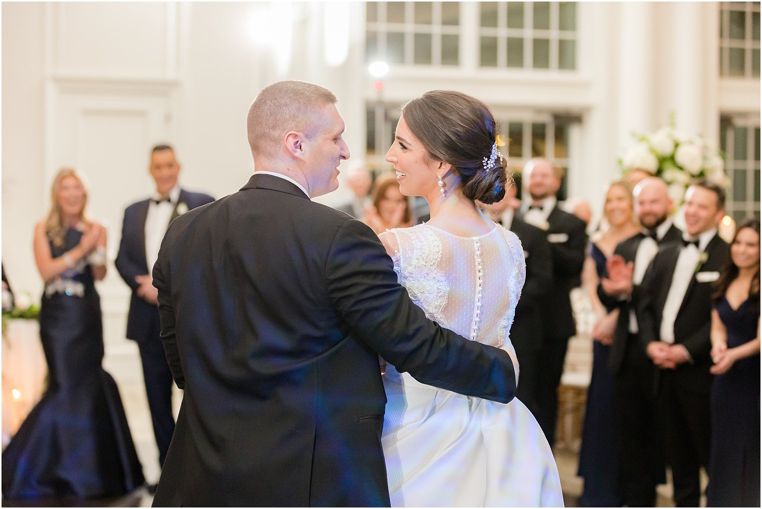 groom looks at bride spinning her on dance floor 