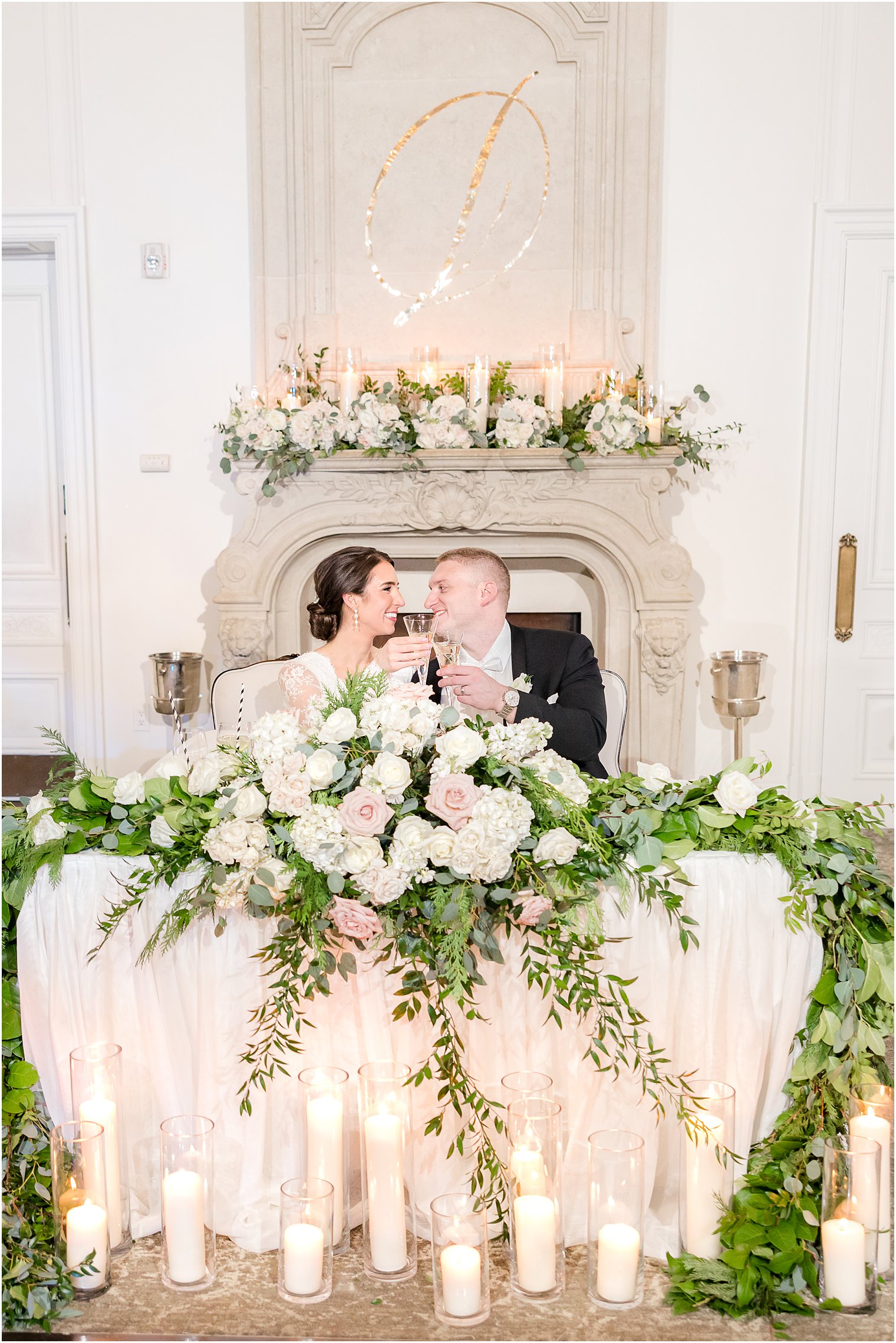 newlyweds kiss at sweetheart table by fireplace at Park Chateau Estate