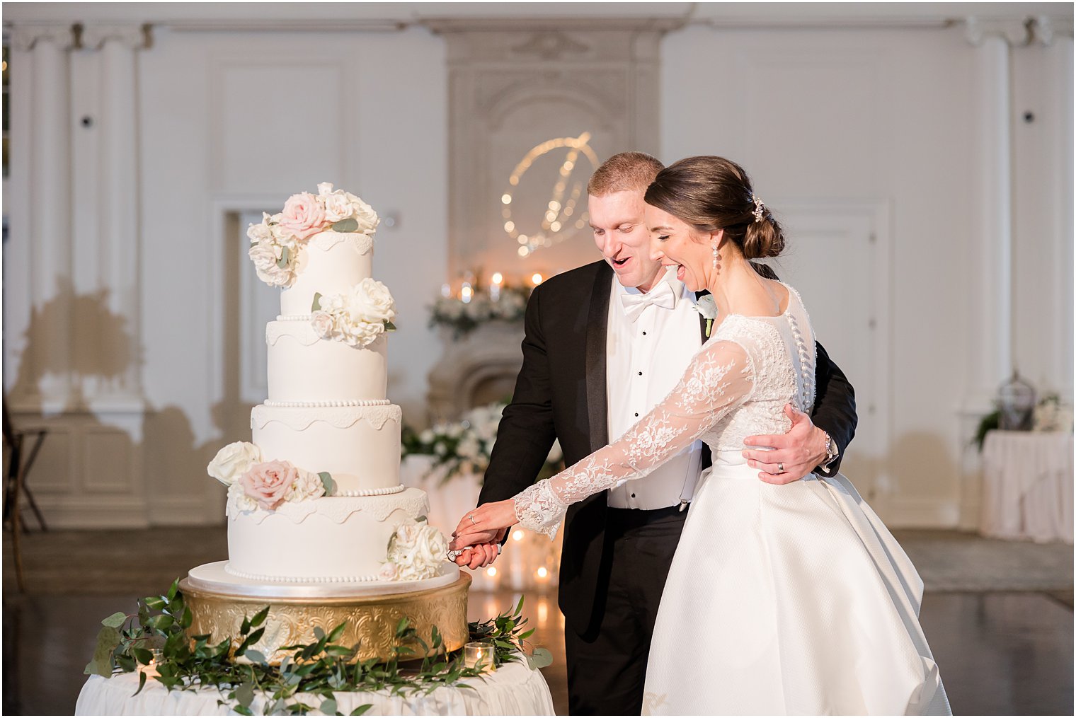newlyweds laugh cutting wedding cake at NJ reception 