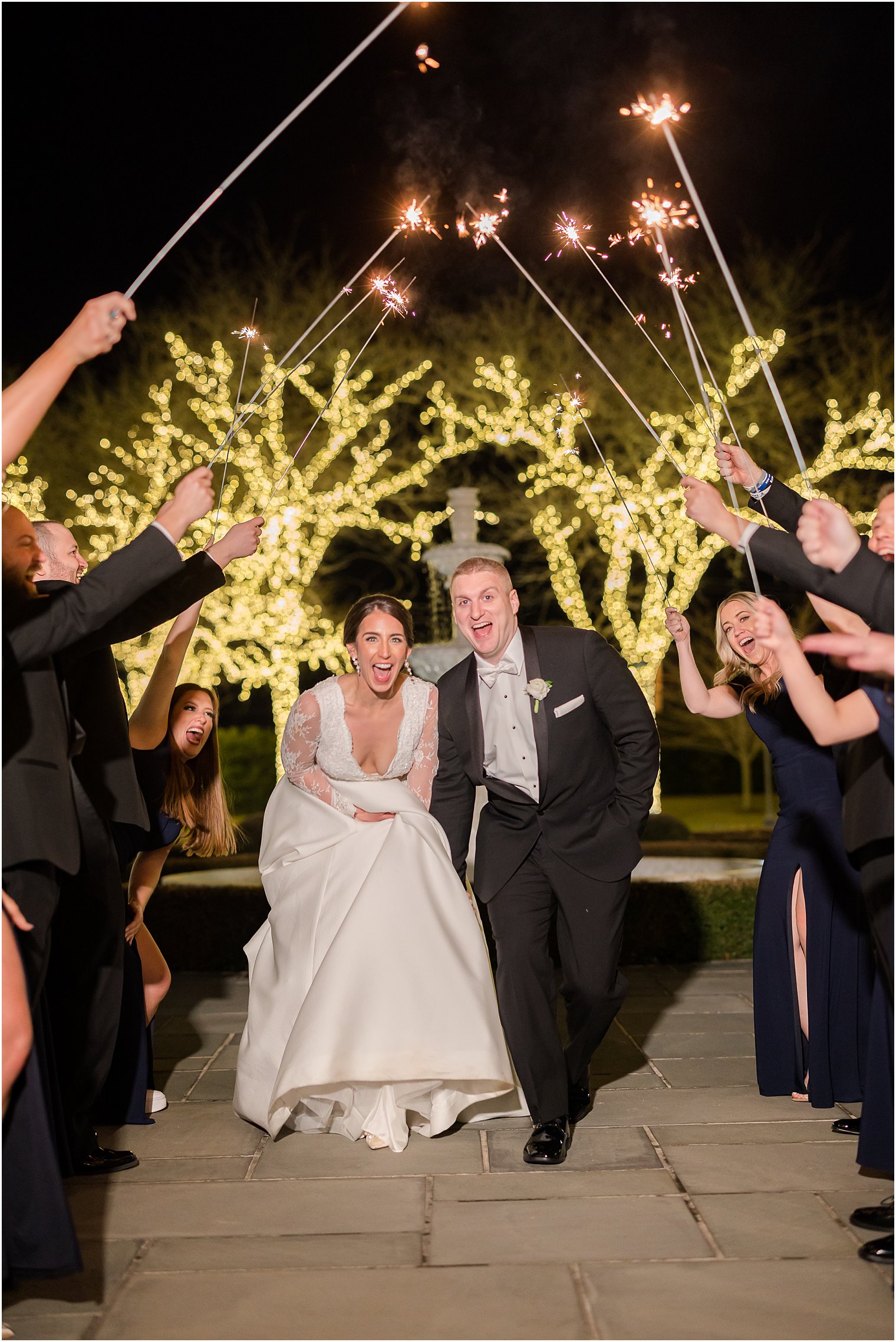 bride and groom laugh running through sparklers outside Park Chateau Estate