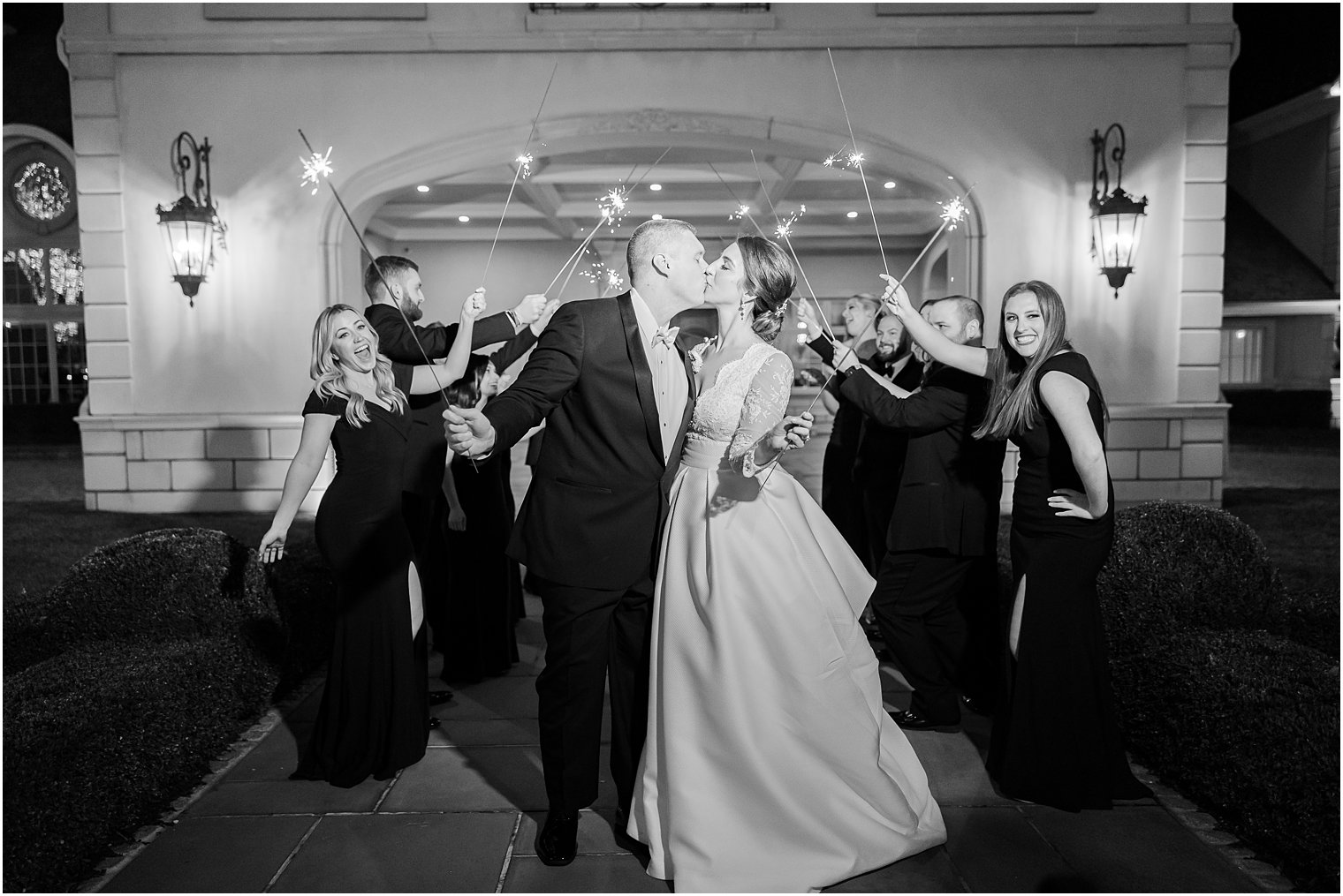 newlyweds kiss with sparklers behind them 