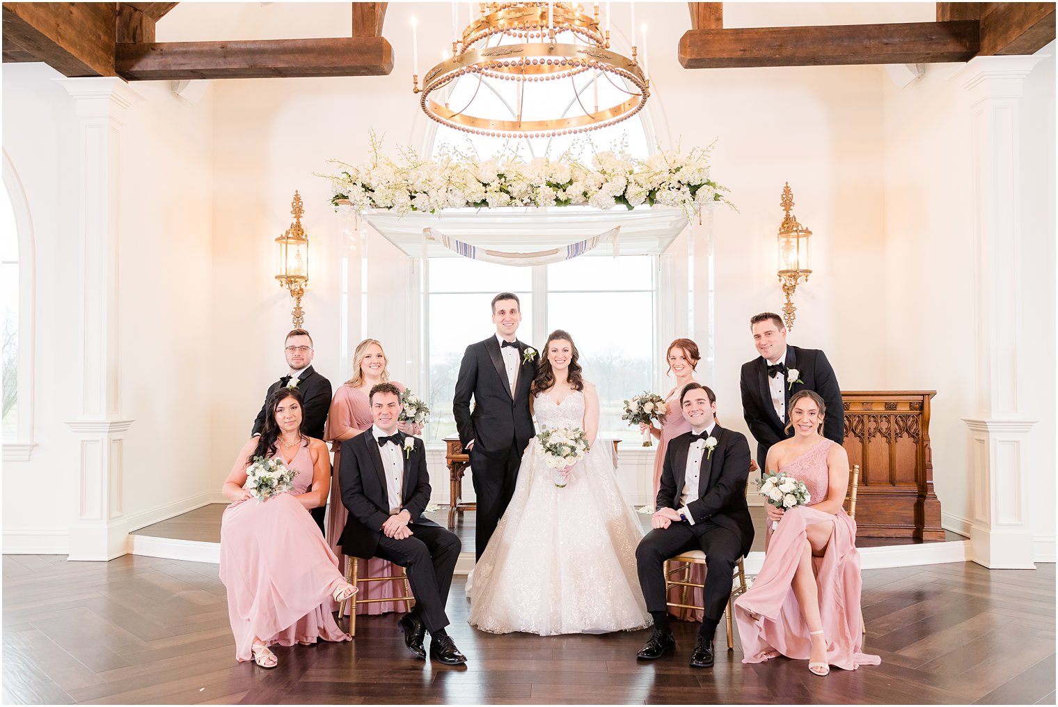 bride and groom stand with bridal party around them near chuppah in Park Savoy Estate