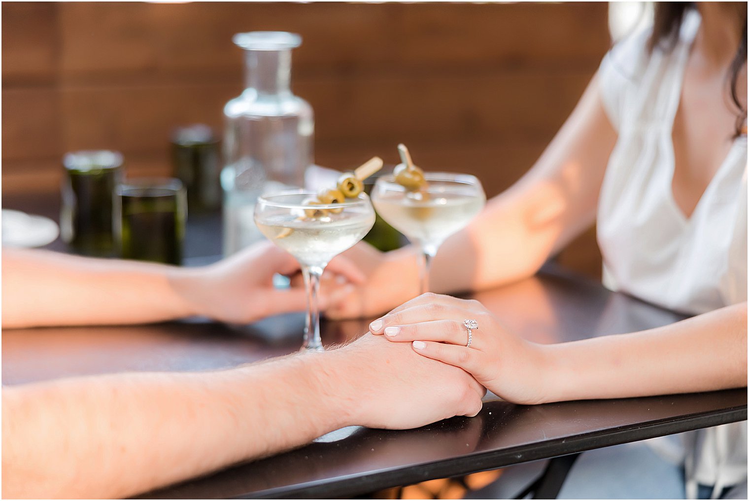 couple holds hands over drinks in Hoboken musical