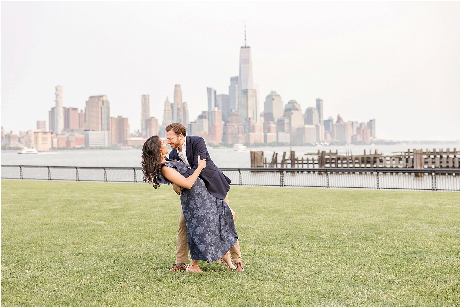 groom dips bride during Hoboken engagement session in front of NYC skyline 
