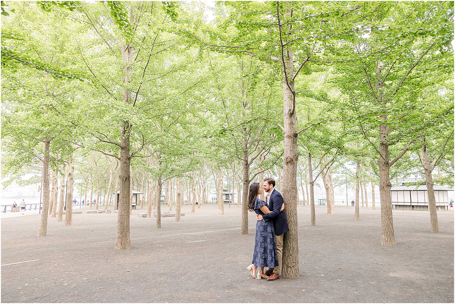 engaged couple kisses against tree during Hoboken engagement session